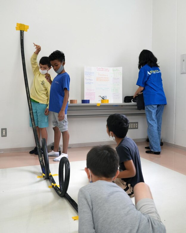 Lisa, a 13-year-old student at the AmerAsian School in Okinawa allows other students to test out her "Rocking Roller Coaster" designed to visually represent and display kinetic energy during a science fair held at the school on February 24. The school is home to 63 students, most being half Japanese and half American. Two Engineers, JED representatives Dr. Rex Mols, OAO’s Host Nation Branch Chief, and Brian Ciccocioppo, Resident Engineer of Okinawa’s Torii Office, have volunteered their own time to encourage interest in science, technology, engineering, and math (STEM) at the local school as a way of giving back to the local Okinawan community.
