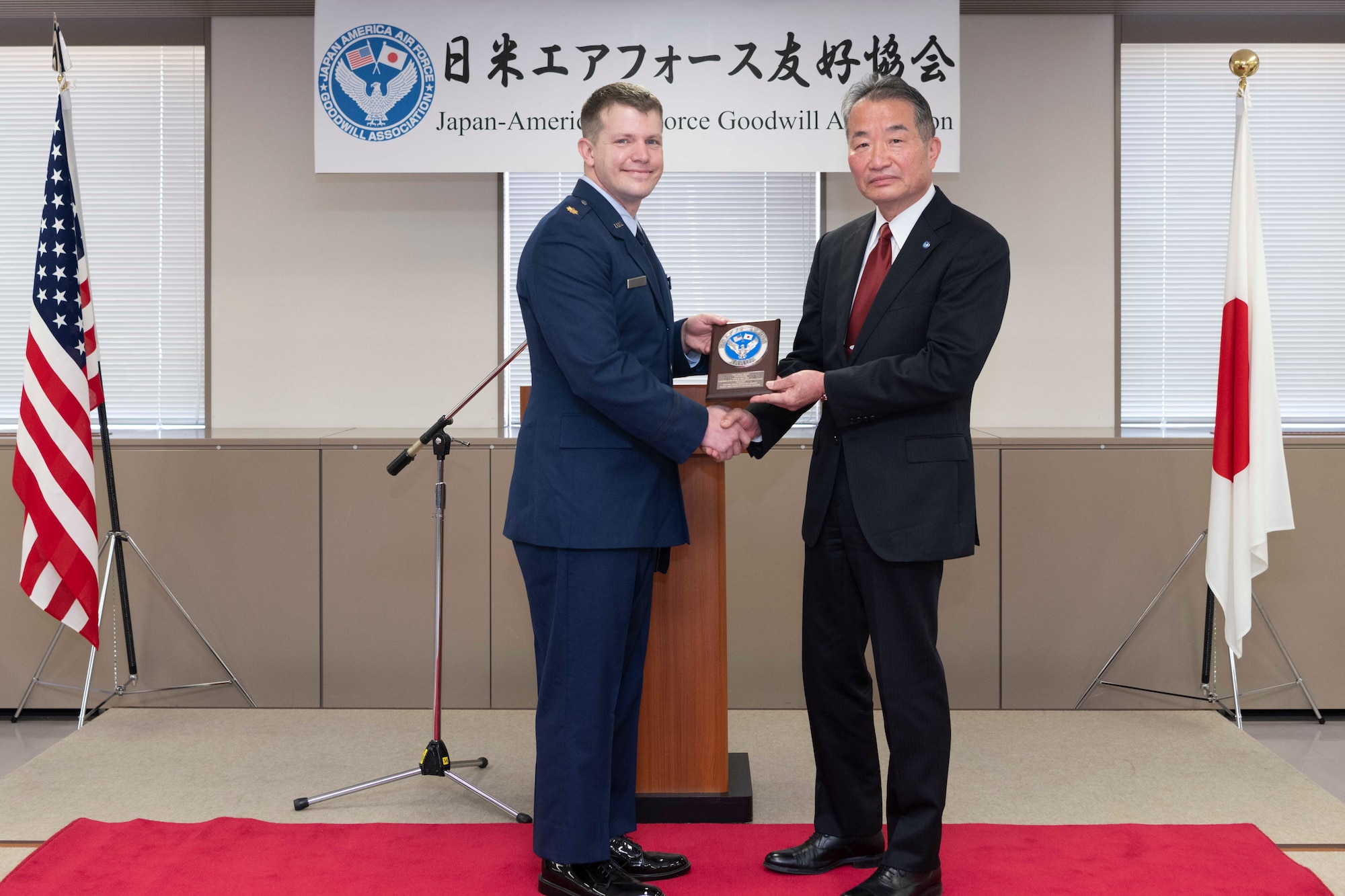 Maj. Lance Mazzella, 374th Logistics Readiness Squadron director of operations, accepts the Japan-America Air Force Goodwill Association Award plaque from Yoshiyuki Sugiyama, JAAGA president, during a ceremony at Yokota Air Base, Japan, March 3, 2023