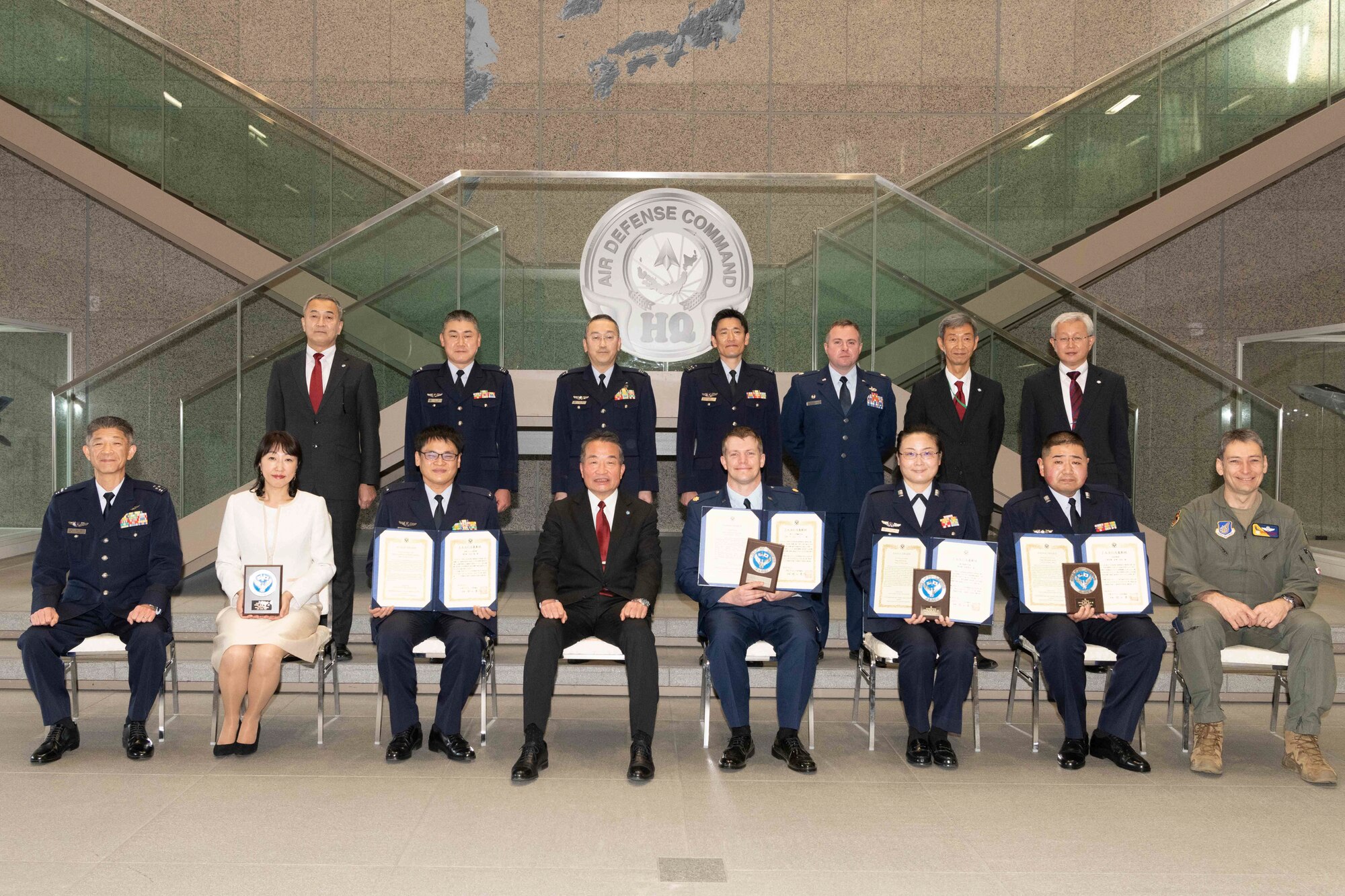 Maj. Lance Mazzella, 374th Logistics Readiness Squadron director of operations, center right, Yoshiyuki Sugiyama, Japan-America Air Force Goodwill Association Award president, center left, pose for a photo with other JAAGA Award recipients and members of JAAGA alongside 374th Airlift Wing and Japan Air Self Defense Force leadership, March 3, 2023, at Yokota Air Base, Japan.