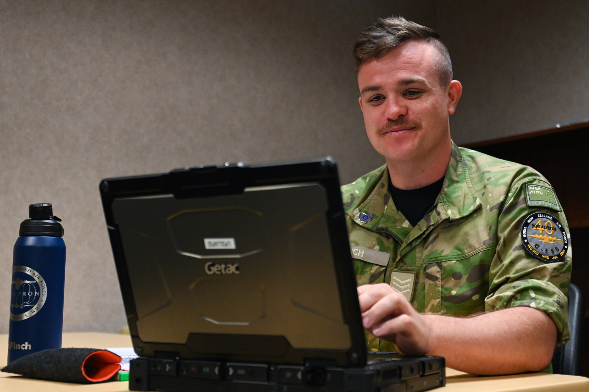 an airman sits at a computer