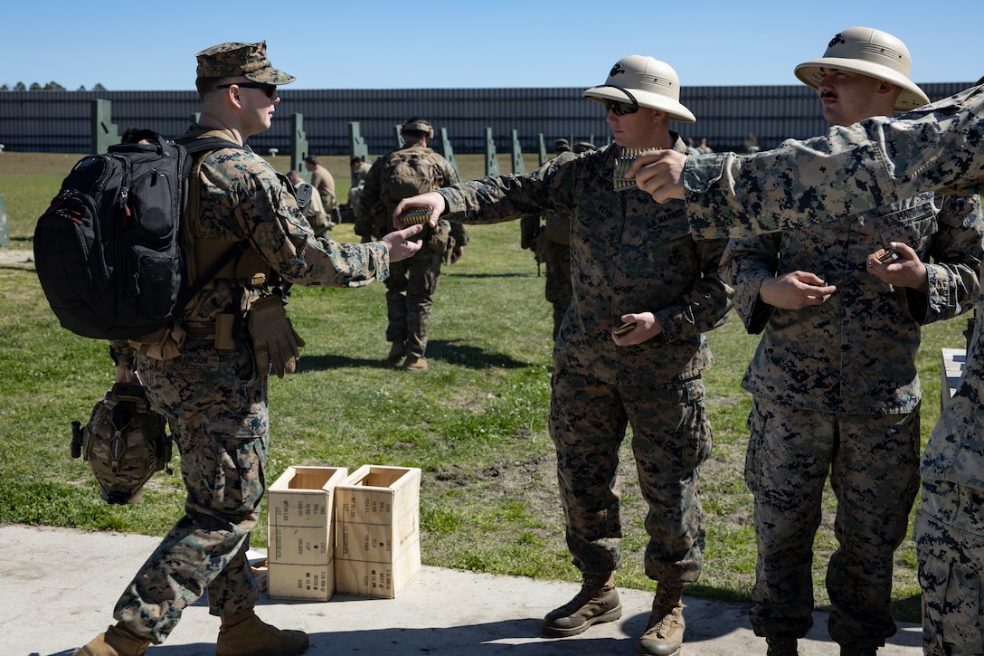 U.S. Marine Corps combat marksmanship coaches with Weapons Training Battalion East hand competitors ammunition before firing during the 2023 Marine Corps Marksmanship Competition East on Stone Bay, Marine Corps Base (MCB) Camp Lejeune, North Carolina, March 6, 2023. All Marines east of the Mississippi were invited to attend this annual competition to increase their combat effectiveness and lethality using MCB Camp Lejeune's premier ranges. (U.S. Marine Corps photo by Cpl. Antonino Mazzamuto)
