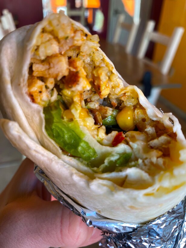 The inside of a chicken burrito served at Rock-N-Roll Burrito, a family-owned Mexican cantina-style establishment located near Naval Air Facility Atsugi. Customers have the choice of several marinated meats, along with ingredients like cilantro-infused rice, corn, jalapenos, and freshly made guacamole. Sauces range from a cilantro-based cream sauce to a tongue-tingling spicy sauce.