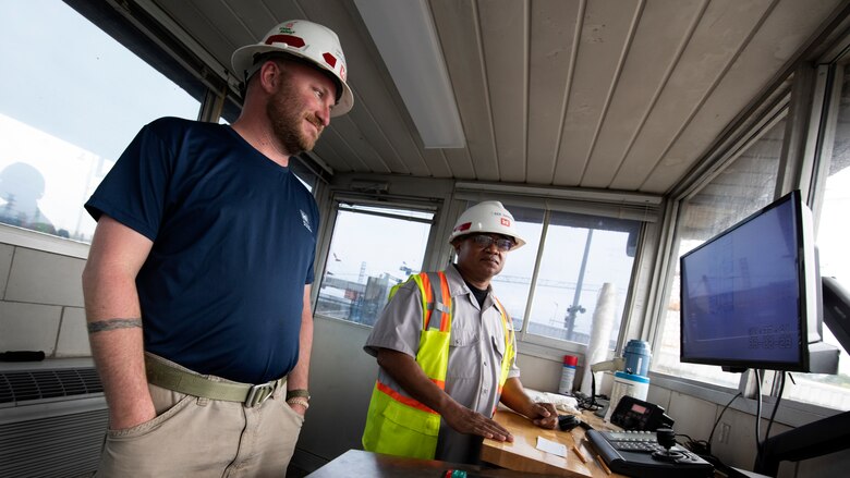 Lockmaster Cory Richardson (Left) and Lock Operator Kenneth Hammock observe an approaching vessel working in the Chickamauga Lock control stand March 2, 2023. The team works to safeguard navigators at the active lock on the Tennessee River, which is very close to a U.S. Army Corps of Engineers Nashville District construction project to build a new 600-foot-long by 110-foot-wide lock. (USACE Photo by Lee Roberts)