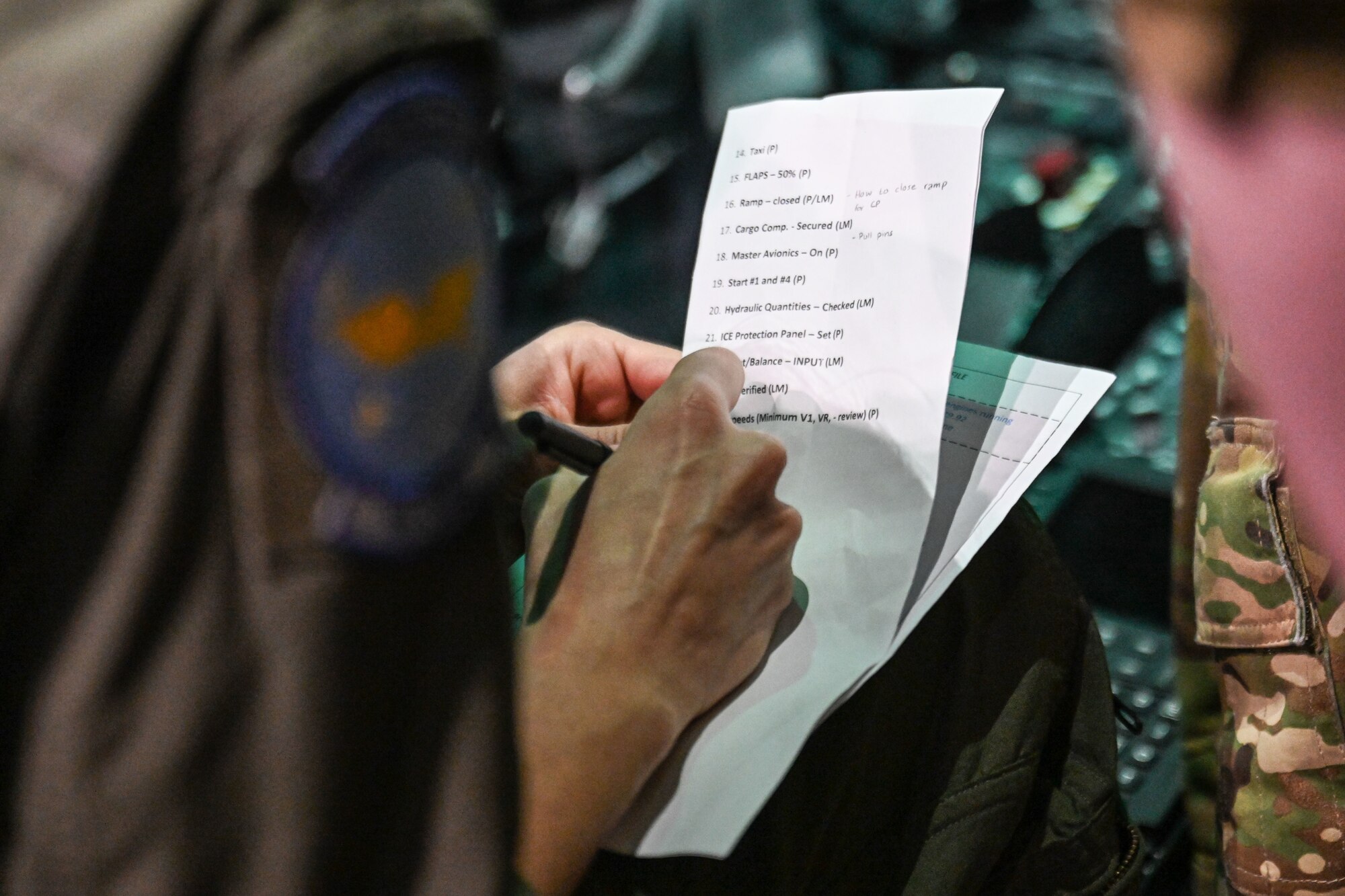 a pilot writes notes on a piece of paper