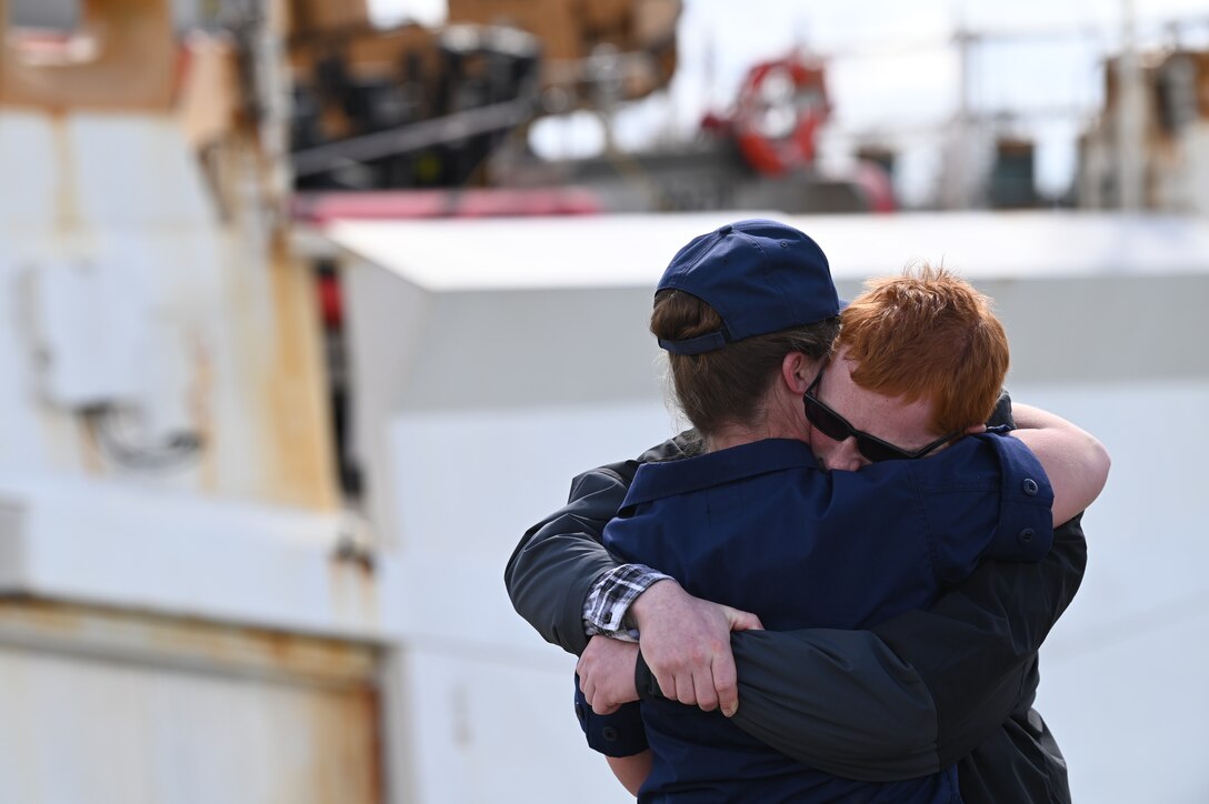 Petty Officer 2nd Class Hannah Capps hugs her son after the Coast Guard Cutter Munro (WMSL 755) returned to Alameda, Calif., March 6, 2023, following a 105-day, 11,500-nautical mile Alaska Patrol. Munro partnered with NOAA Office of Law Enforcement personnel to conduct 24 boardings of commercial fishing vessels with the goal of enforcing sustainable fishing practices and ensuring compliance with federal regulations. U.S. Coast Guard Cutter Munro returns from Alaska Patrol. U.S. Coast Guard photo by Chief Petty Officer Matthew S. Masaschi.