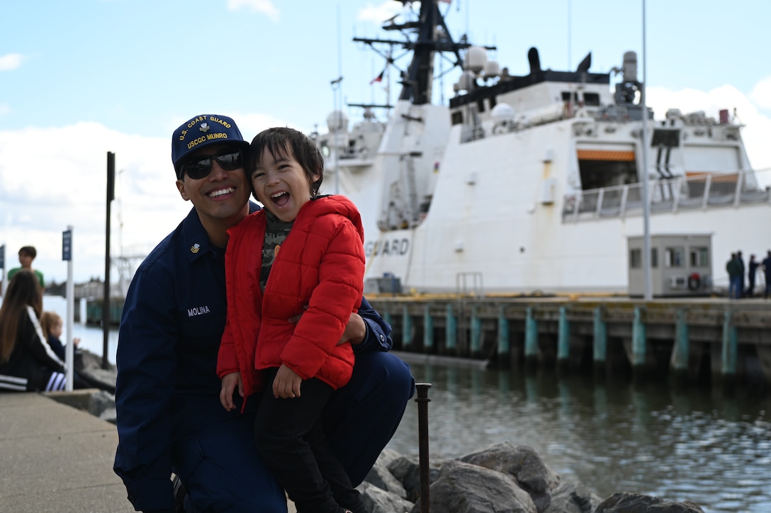 Petty Officer 1st Class Robert Molina hugs his son after the Coast Guard Cutter Munro (WMSL 755) returned to Alameda, Calif., March 6, 2023, following a 105-day, 11,500-nautical mile Alaska Patrol. Munro partnered with NOAA Office of Law Enforcement personnel to conduct 24 boardings of commercial fishing vessels with the goal of enforcing sustainable fishing practices and ensuring compliance with federal regulations. U.S. Coast Guard photo by Chief Petty Officer Matthew S. Masaschi.
