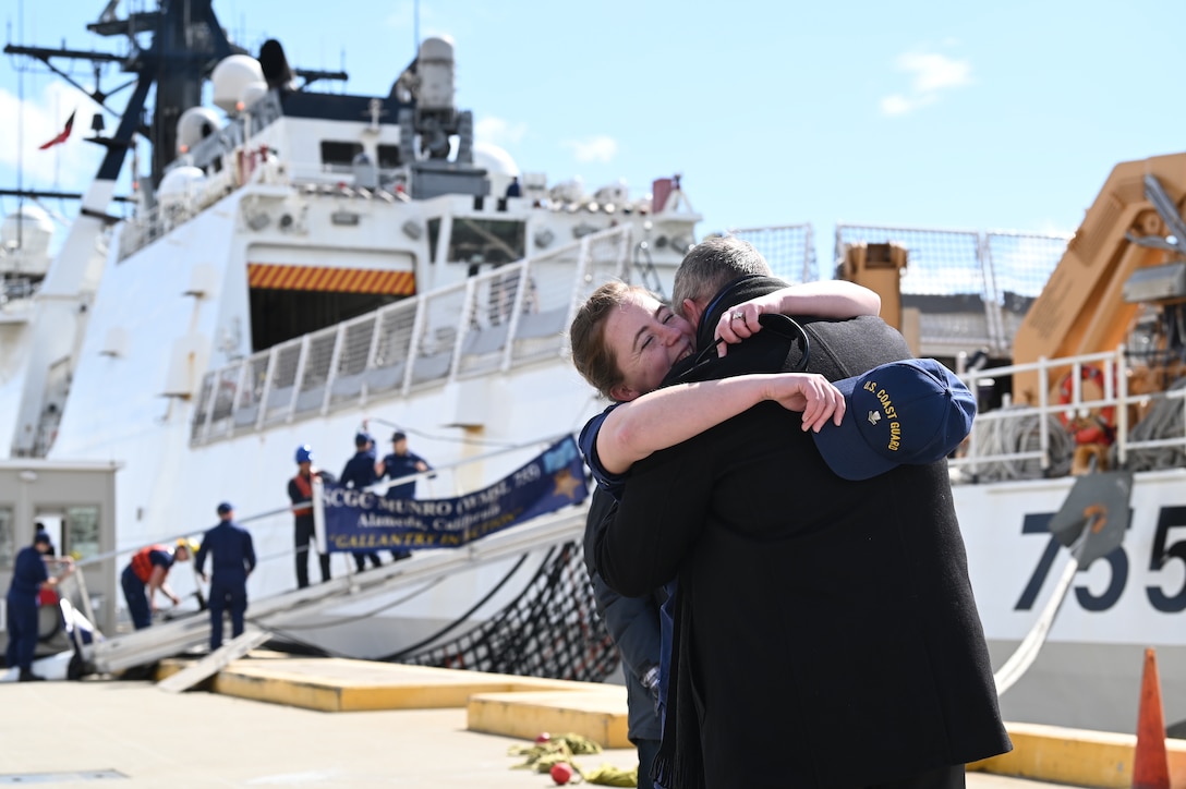 Petty Officer 2nd Class Hannah Capps hugs her spouse after the Coast Guard Cutter Munro (WMSL 755) returned to Alameda, Calif., March 6, 2023, following a 105-day, 11,500-nautical mile Alaska Patrol. Munro partnered with NOAA Office of Law Enforcement personnel to conduct 24 boardings of commercial fishing vessels with the goal of enforcing sustainable fishing practices and ensuring compliance with federal regulations. U.S. Coast Guard Cutter Munro returns from Alaska Patrol. U.S. Coast Guard photo by Chief Petty Officer Matthew S. Masaschi.