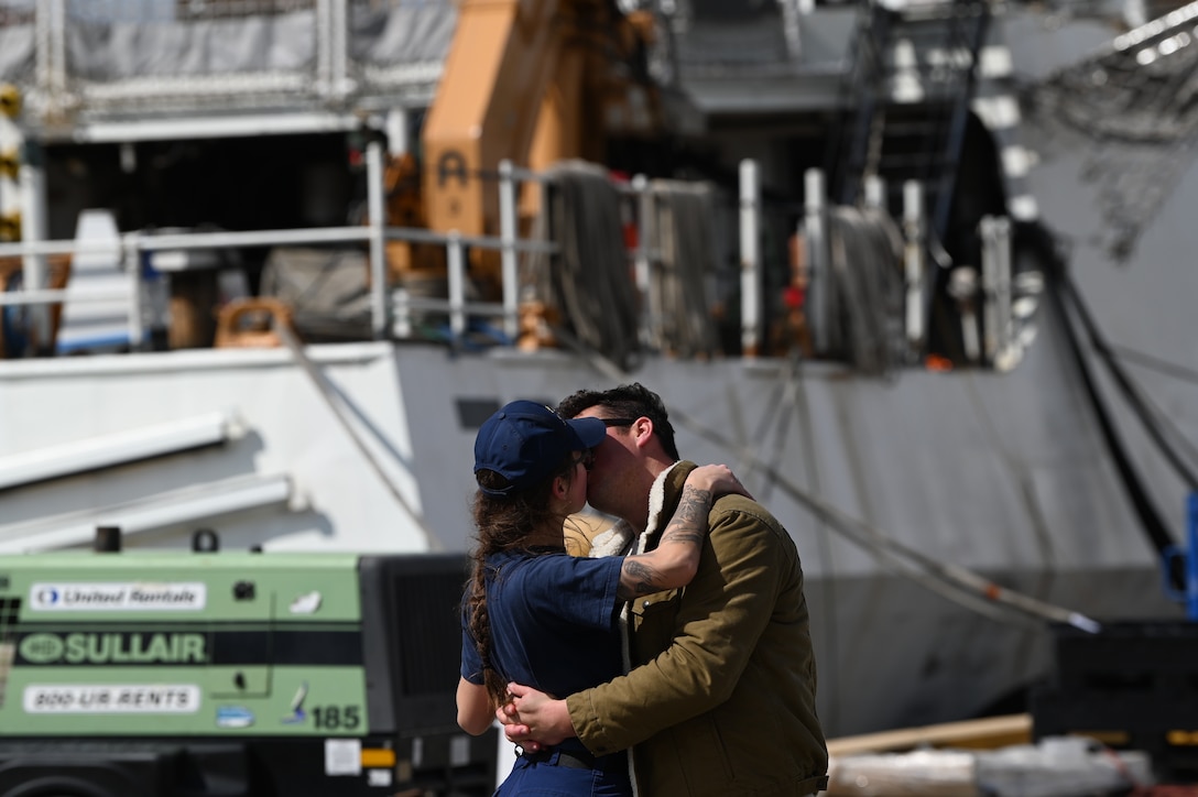 A Coast Guard Cutter Munro (WMSL 755) crewmember kisses her significant other after the Munro returned to Alameda, Calif., March 6, 2023, following a 105-day, 11,500-nautical mile Alaska Patrol. Munro partnered with NOAA Office of Law Enforcement personnel to conduct 24 boardings of commercial fishing vessels with the goal of enforcing sustainable fishing practices and ensuring compliance with federal regulations. U.S. Coast Guard Cutter Munro returns from Alaska Patrol. U.S. Coast Guard photo by Chief Petty Officer Matthew S. Masaschi.