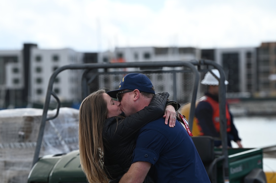 Petty Officer 2nd Class Aundré Behnken kisses his spouse after the Coast Guard Cutter Munro (WMSL 755) returned to Alameda, Calif., March 6, 2023, following a 105-day, 11,500-nautical mile Alaska Patrol. Munro partnered with NOAA Office of Law Enforcement personnel to conduct 24 boardings of commercial fishing vessels with the goal of enforcing sustainable fishing practices and ensuring compliance with federal regulations. U.S. Coast Guard Cutter Munro returns from Alaska Patrol. U.S. Coast Guard photo by Chief Petty Officer Matthew S. Masaschi.