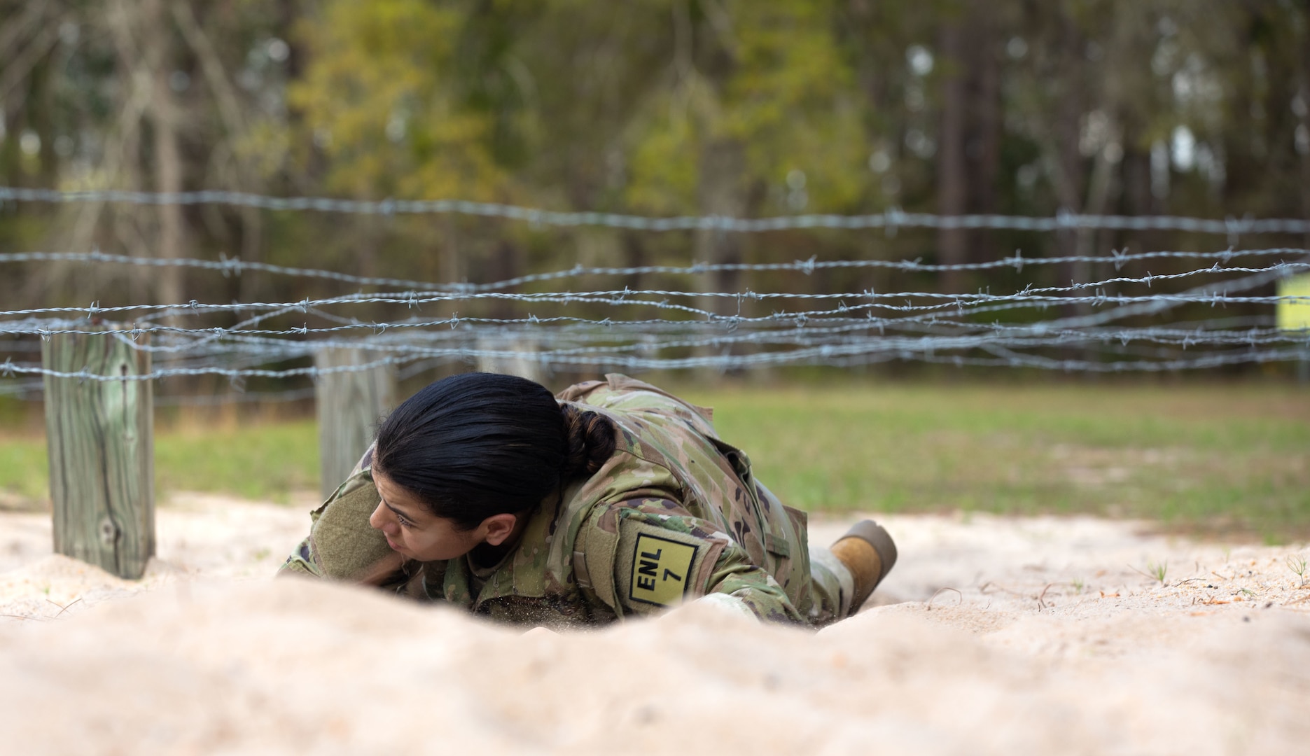 U.S. Army Spc. Mary Ruiz, an aviation operations specialist representing the 78th Aviation Troop Command, crawls under barbed wire during the obstacle course portion of the 2023 Georgia National Guard State Best Warrior Competition at Fort Stewart, Georgia, March 6, 2023. The competition tested readiness and adaptiveness of Georgia's best Soldiers.