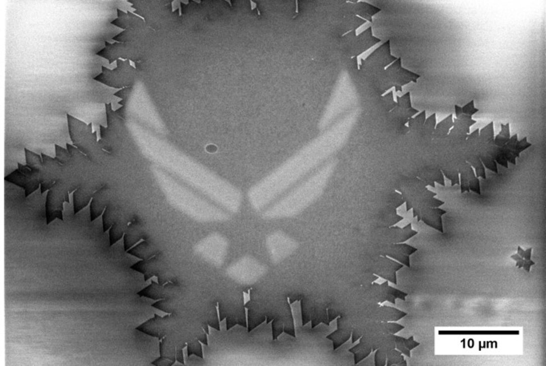 The image depicts a novel precision patterning method using the United States Department of the Air Force emblem on monolayer MoSe2, a two-dimensional material made of atomic layers. Air Force Research Laboratory, or AFRL, researchers from the Materials and Manufacturing Directorate contributed this work to the February 2023 ACS Nano publication “Precision Modification of Monolayer Transition Metal Dichalcogenides via Environmental E‑Beam Patterning.” The publication introduced an innovative process of altering and tailoring the optoelectronic properties of transition metal dichalcogenides, or TMDs. Researchers can control and manipulate the atomic properties of these materials to draw lines, shapes and desired patterns to demonstrate how the material’s thermal and optical properties can be manipulated for sensing and other technologies. (U.S. Air Force graphic)