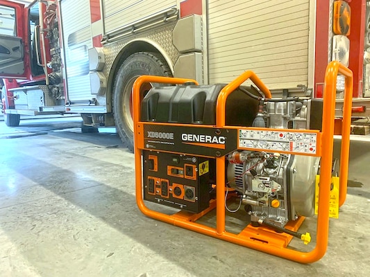 A generator sits near a firetruck.