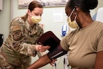 Medical technician checks patient's blood pressure