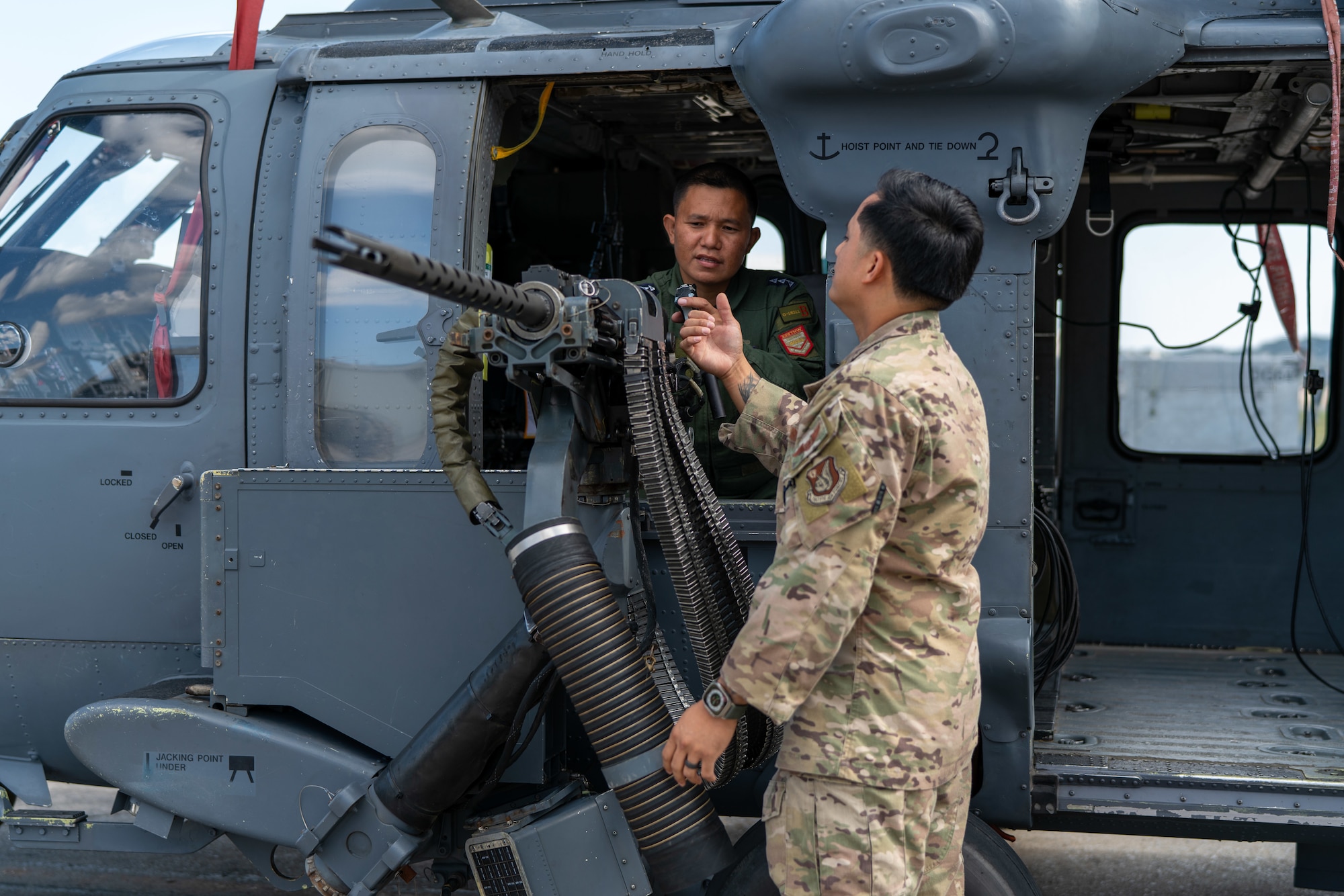 An Airman explains machine gun details to a Philippine Air Force member.
