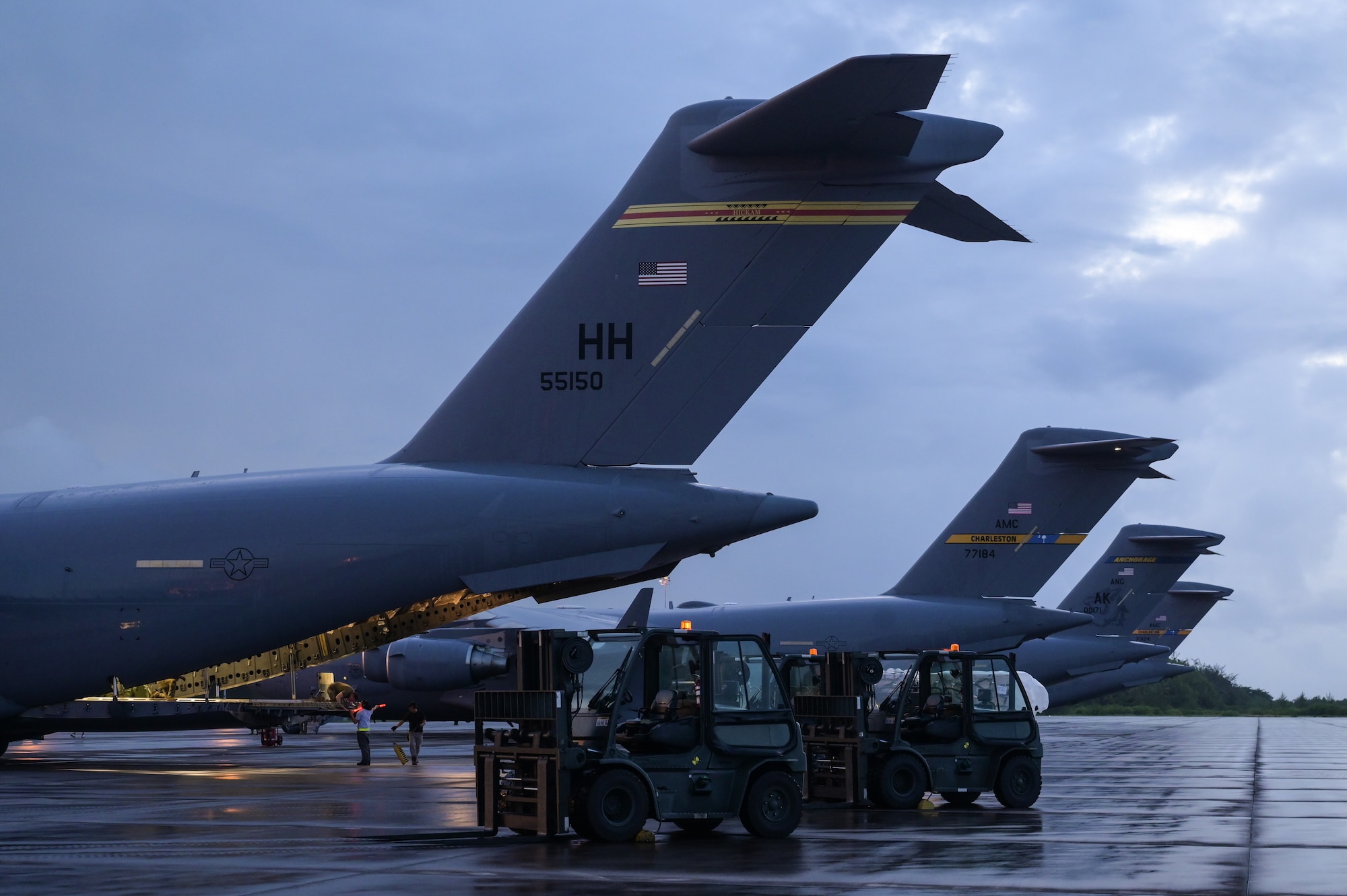 Contractor personnel transport cargo to U.S. Air Force C-17 Globemaster IIIs, assigned to Joint Base Pearl Harbor-Hickam, Hawaii, Joint Base Charleston, South Carolina, and Joint Base Elmendorf-Richardson, Alaska, during Exercise Cobra Gold 2023 on a flight line at Diego Garcia, British Indian Ocean Territory, Mar. 1, 2023. Cobra Gold, now in its 42nd year, is a Thai-U.S. co-sponsored training event that builds on the long-standing friendship between the two allied nations and brings together a robust multinational force to promote regional peace and security in support of a free and open Indo-Pacific. (U.S. Air Force photo by Staff Sgt. Alan Ricker)