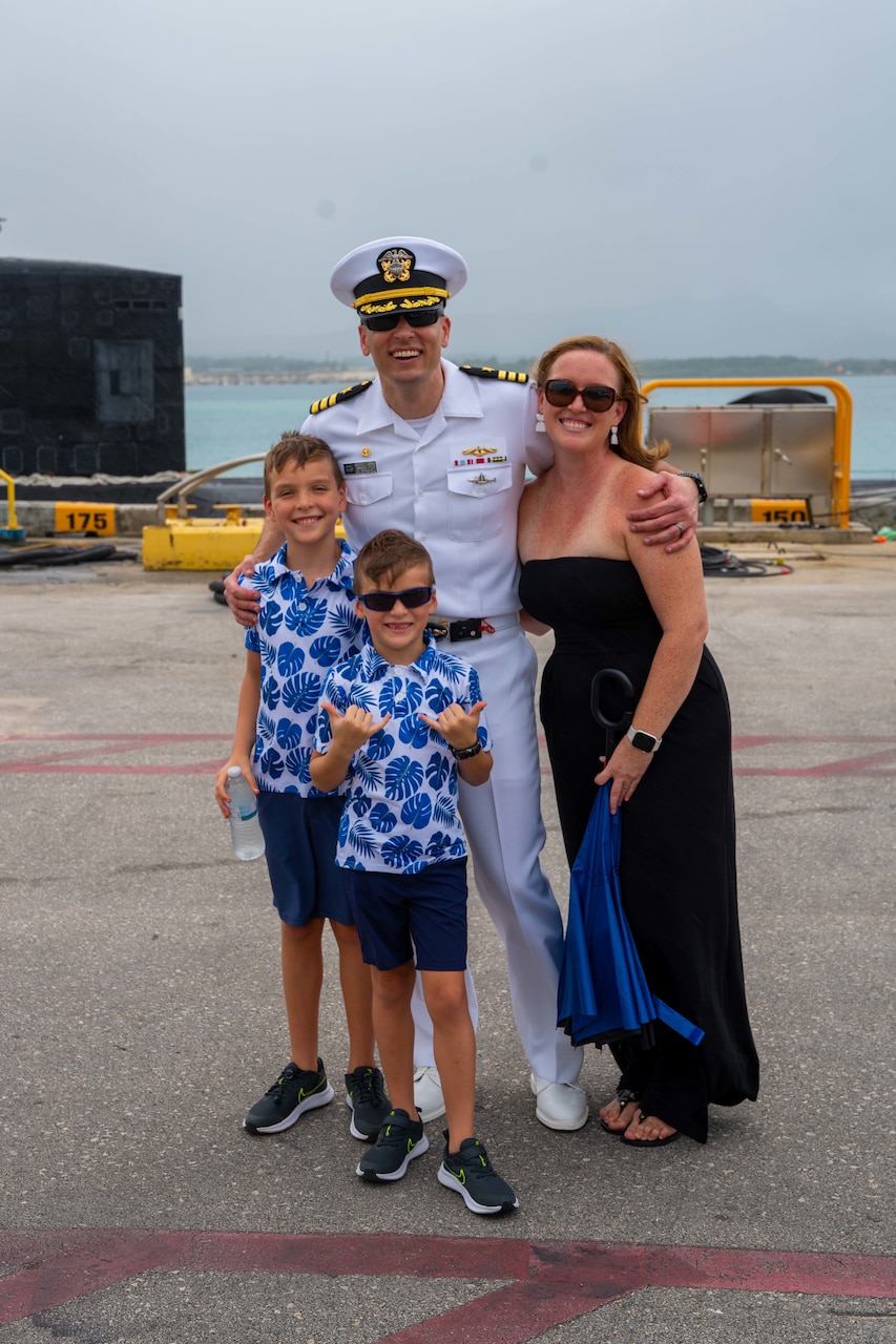 POLARIS POINT, Guam (Jan. 9, 2023) Cmdr. Andrew Domina, commanding officer of the Los Angeles-class fast-attack submarine USS Springfield (SSN 761), and his family pose for a photo after Springfield’s return to Guam from deployment, Jan. 9. Springfield is capable of supporting various missions, including anti-submarine warfare, anti-ship warfare, strike warfare and intelligence, surveillance reconnaissance. (U.S. Navy photo by Lt. Eric Uhden)