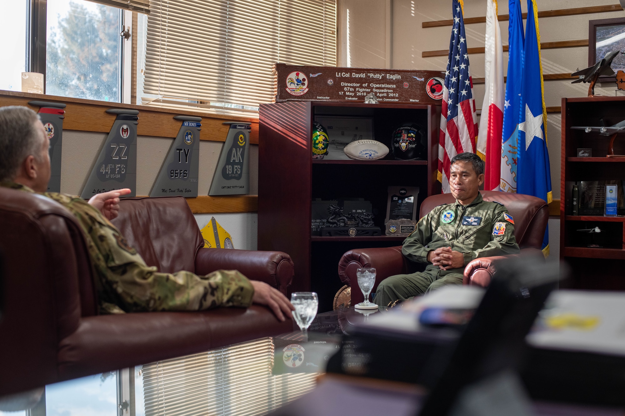 An Airman and Philippine Air Force member sit across from each other.