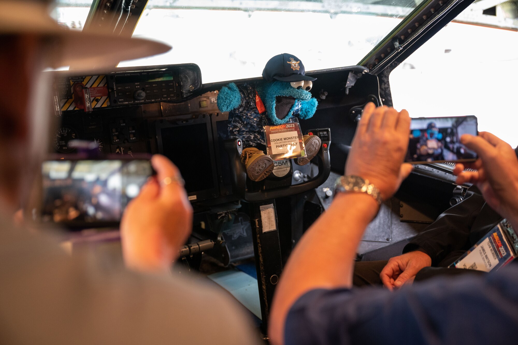 Event volunteers take photos of Cookie Monster—the event mascot—sitting in the cockpit of the C-5 Galaxy during the 2023 Australian International Airshow and Aerospace & Defence Exposition—AVALON 23—at Avalon International Airport, March 1, 2023. The Department of Defense supported AVALON 23 with approximately 300 personnel and a number of various aircraft to include the F-22 Raptor, KC-46 Pegasus, C-17 Globemaster III, AH-64 Apache, M142 HIMARS among many others. The C-5 Galaxy is a strategic transport aircraft and is the largest aircraft in the U.S. Air Force inventory. (U.S. Air Force photo by Tech. Sgt. Hailey Haux)