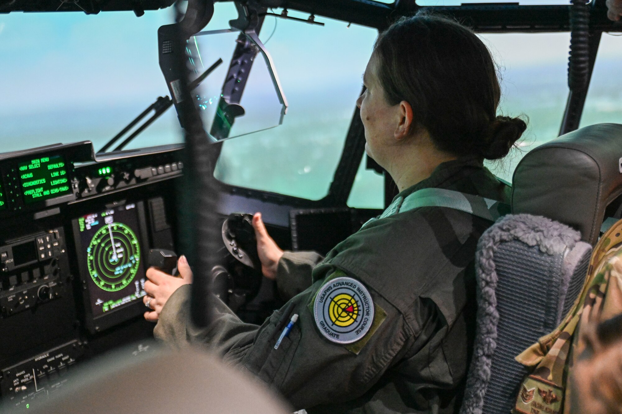 an female aircrew members flies in a C-130 aircraft simulator