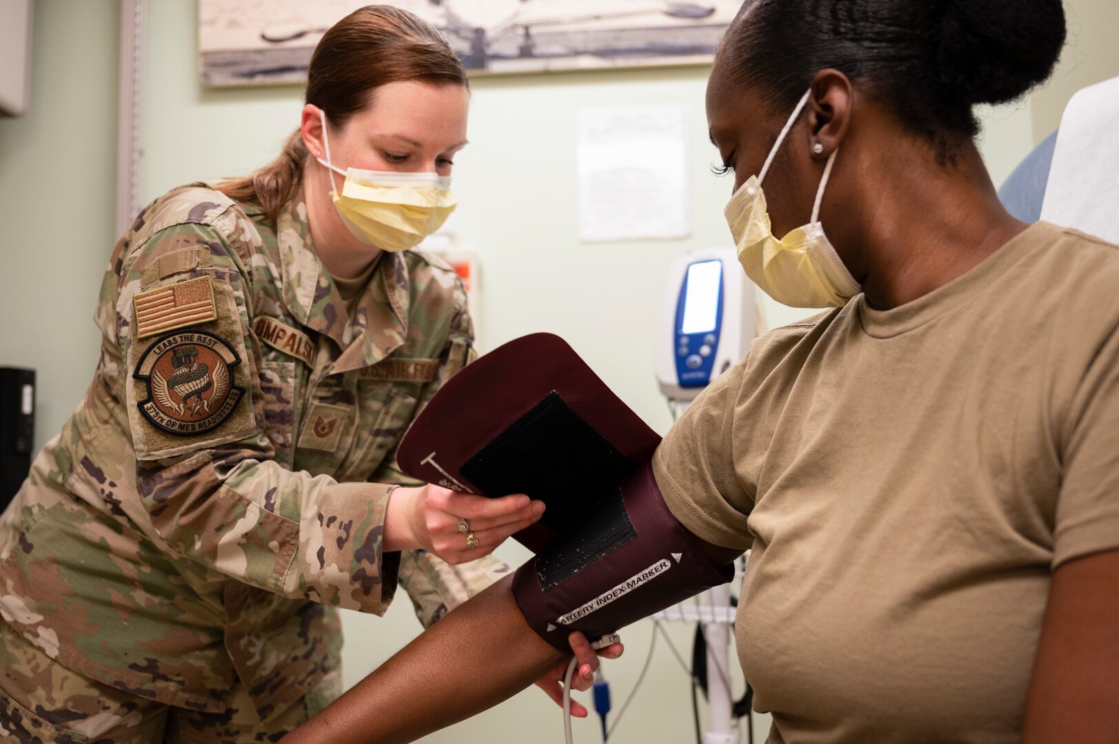Medical technician checks patient's blood pressure
