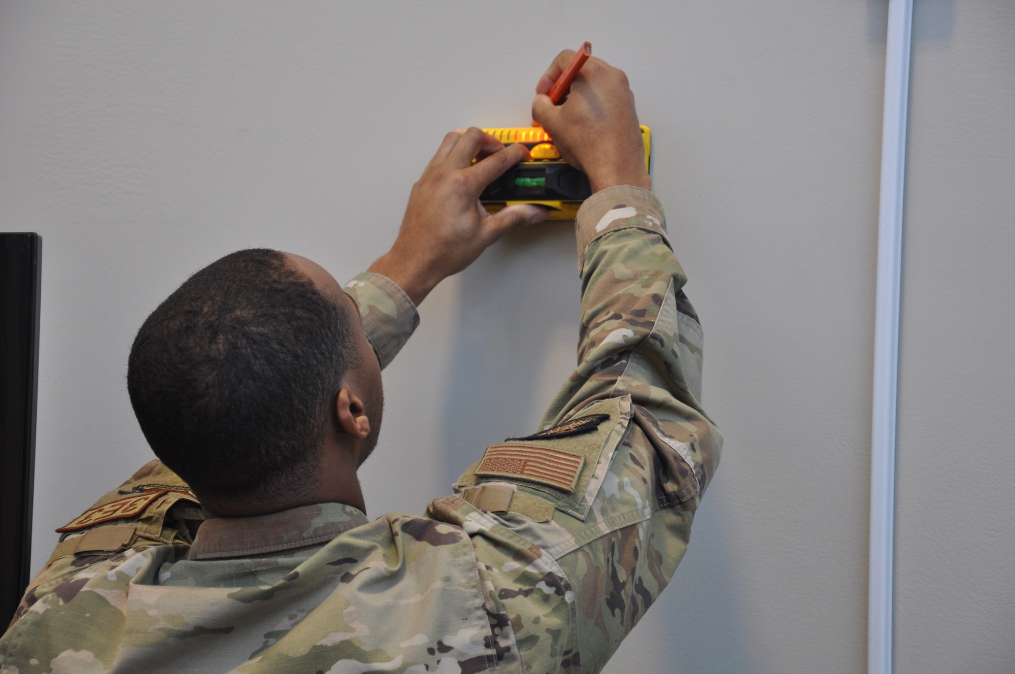 a man marks a stud in a wall