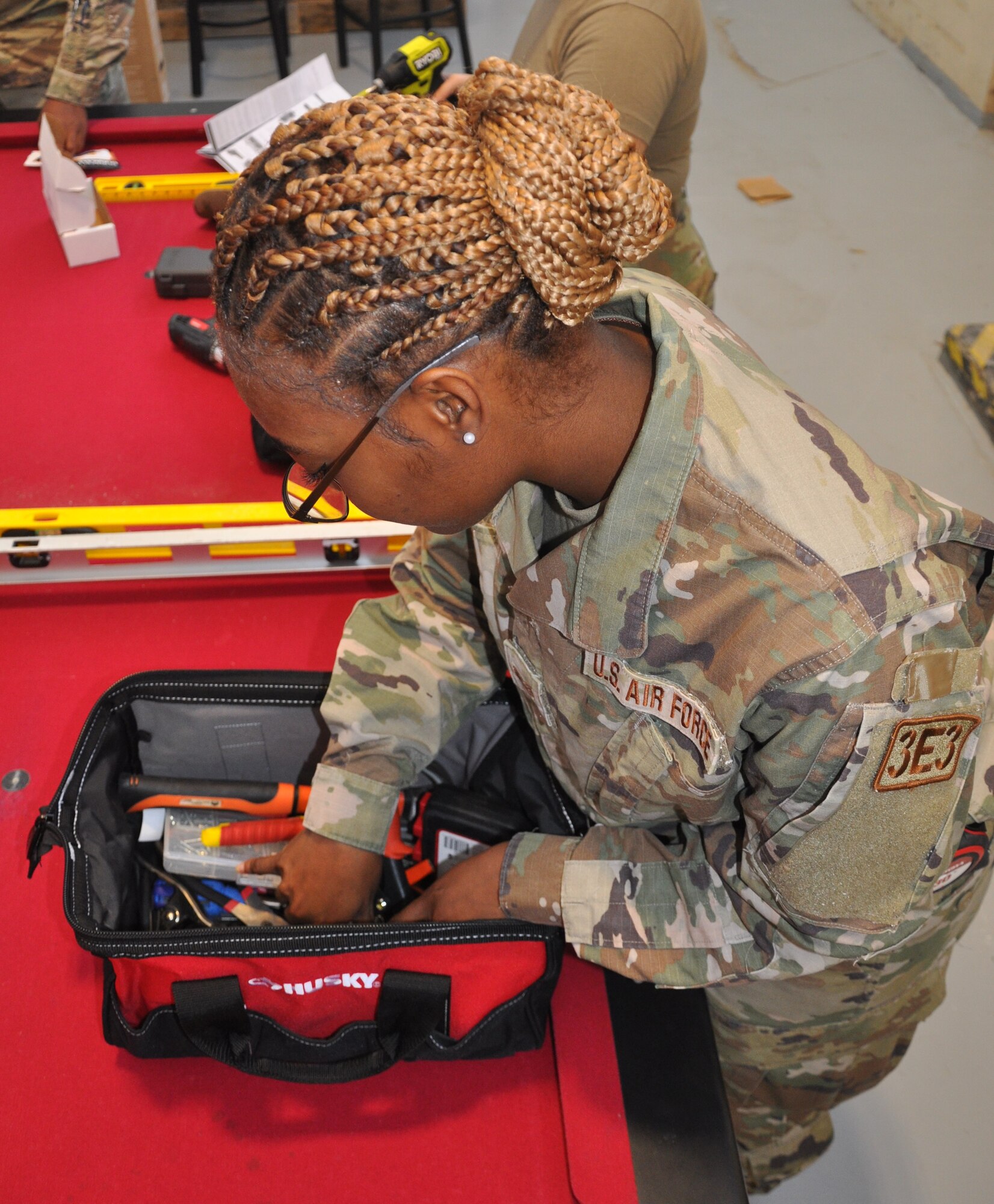 a woman looks for a tool in a bag