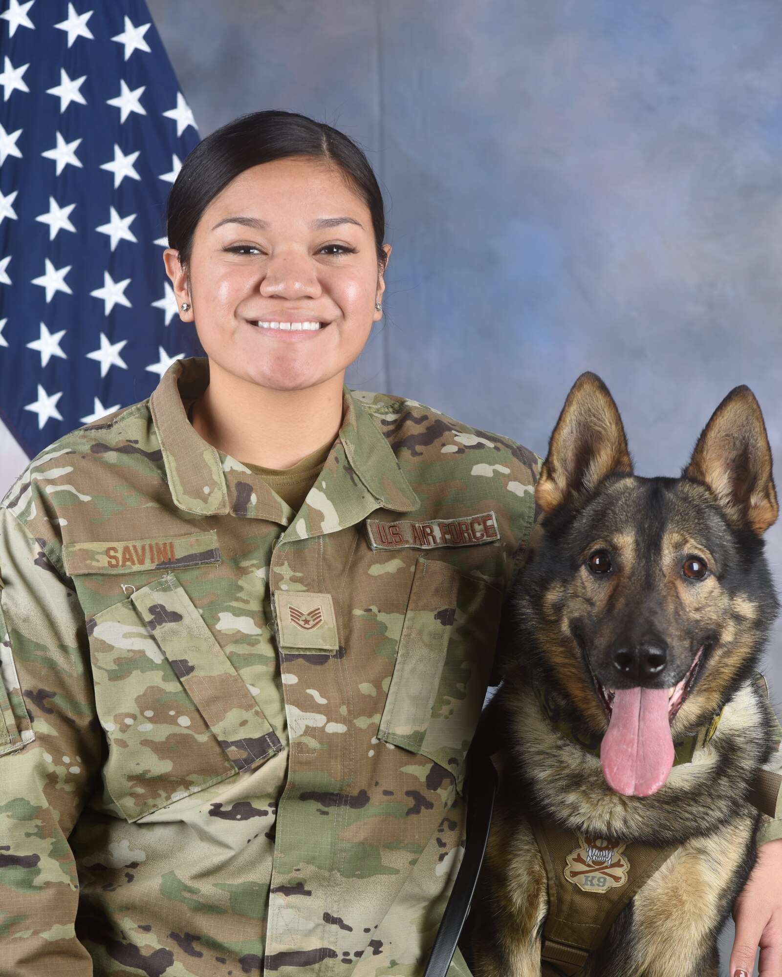 U.S. Air Force Staff Sgt. Destiny Savini, 97th Security Forces Squadron (SFS) military working dog (MWD) handler, poses for an official photo with Bingo, 97th SFS MWD at Altus Air Force Base, Oklahoma, February 1, 2023. Bingo has been assigned to the 97th Air Mobility Wing since 2019. (U.S. Air Force photo by Senior Airman Kayla Christenson)