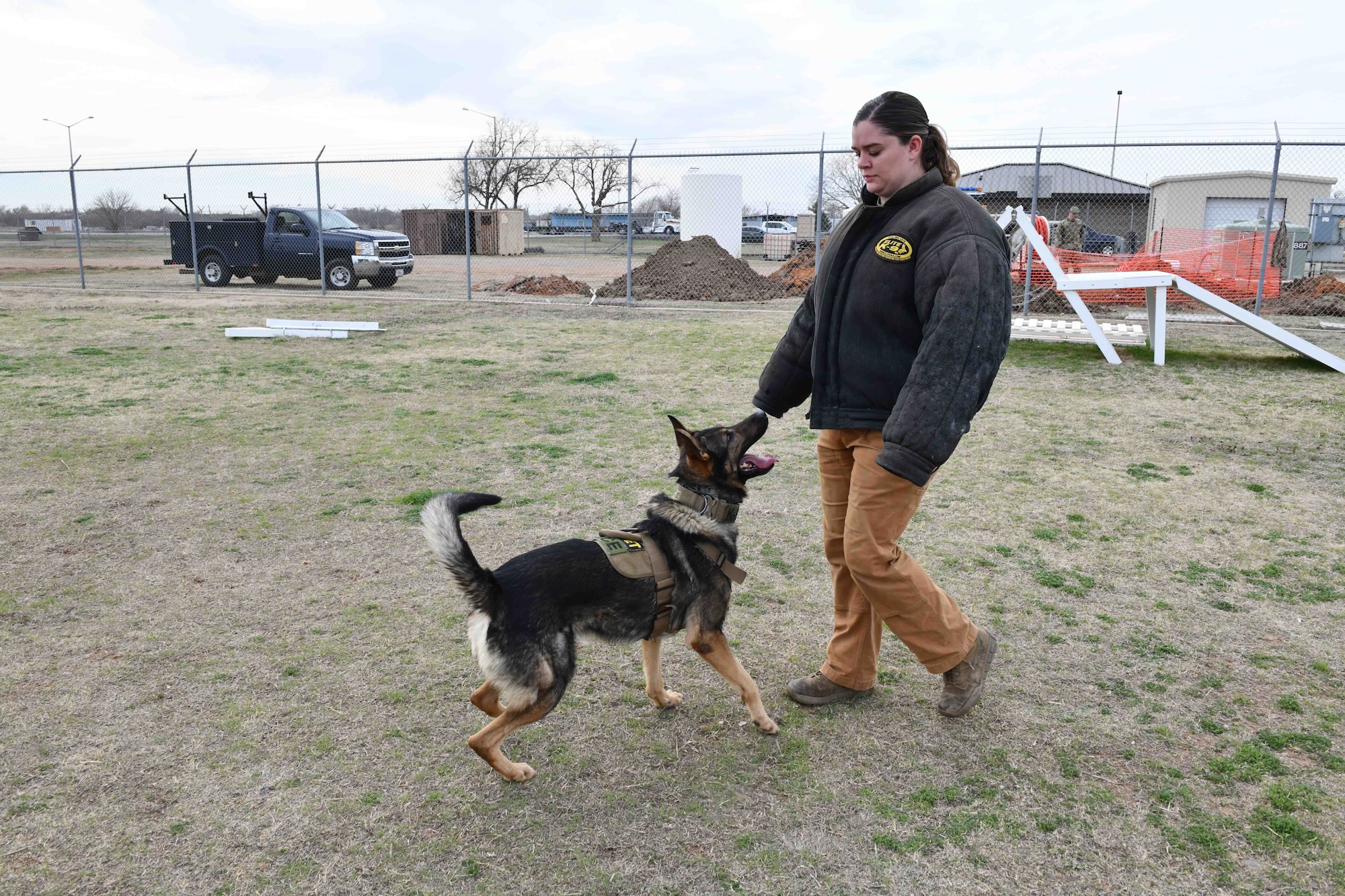 Bingo, 97th Security Forces Squadron (SFS) military working dog (MWD), escorts U.S. Air Force Senior Airman Kaitlynd Newland, 97th SFS MWD handler at Altus Air Force Base, Oklahoma, March 6, 2023. Military working dogs are trained for many purposes such as tracking, attacking, detecting explosives and search and rescue missions. (U.S. Air Force photo by Airman 1st Class Miyah Gray)