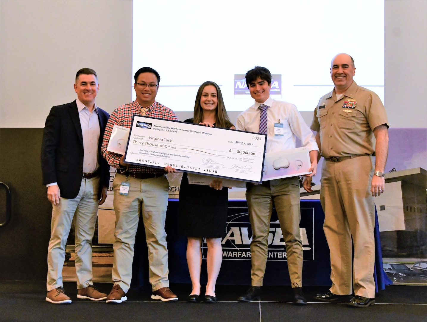 IMAGE: Virginia Tech took home the second place prize of $30,000 on the final day of the Artificial Intelligence and Machine Learning Innovation Challenge at Dahlgren. Pictured from left to right: NSWCDD Technical Director, Dale Sisson, SES, along with Virginia Tech’s team of Anthony Lee, Danielle Reale, Alex Downey and NSWCDD Commanding Officer, Capt. Philip Mlynarski.