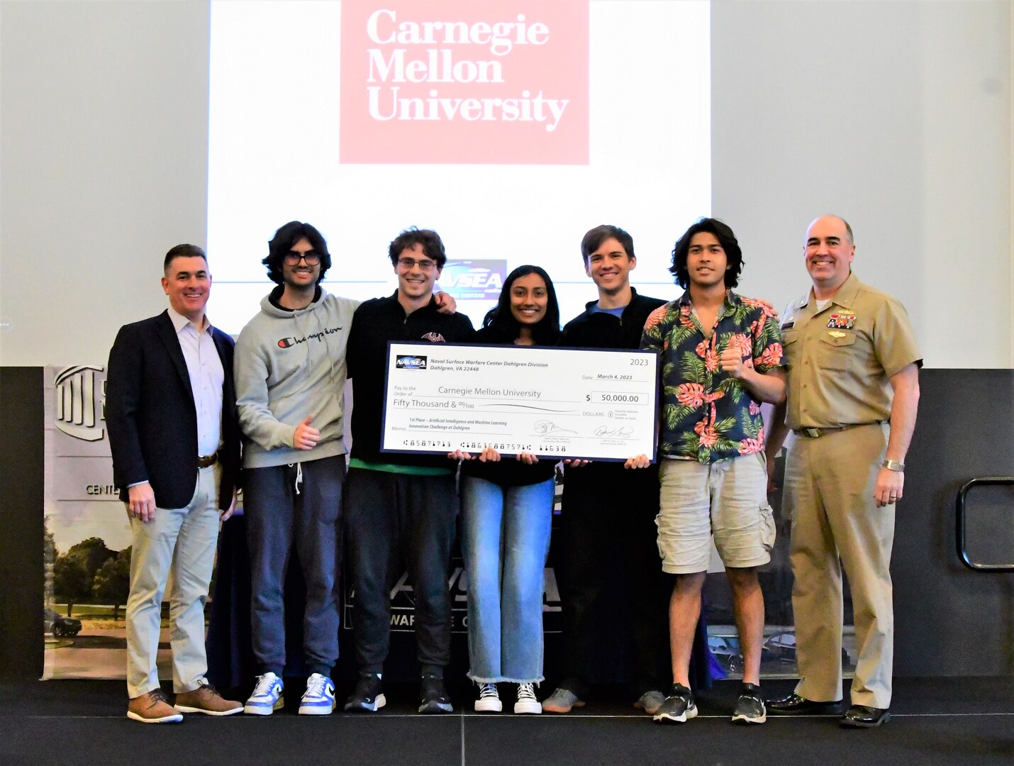 IMAGE: Carnegie Mellon University (CMU) took home first place honors during the Artificial Intelligence and Machine Learning Innovation Challenge at Dahlgren, March 2. The students were awarded a $50,000 cash prize for their efforts. Pictured from left to right: NSWCDD Technical Director Dale Sisson, SES, CMU team members Lucas Darcy, Austin Weltz, Medha Palavalli, Matthew Garcia, Pranav Rajbhandari and NSWCDD Commanding Officer, Capt. Philip Mlynarski.