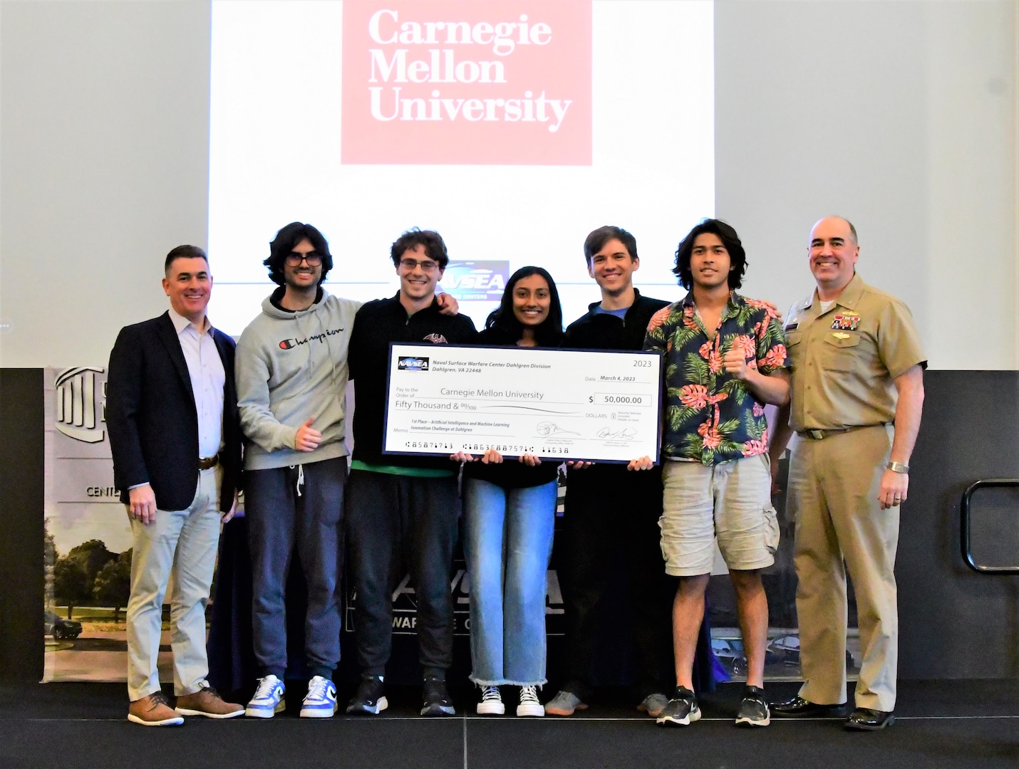 IMAGE: Carnegie Mellon University (CMU) took home first place honors during the Artificial Intelligence and Machine Learning Innovation Challenge at Dahlgren, March 2. The students were awarded a $50,000 cash prize for their efforts. Pictured from left to right: NSWCDD Technical Director Dale Sisson, SES, CMU team members Lucas Darcy, Austin Weltz, Medha Palavalli, Matthew Garcia, Pranav Rajbhandari and NSWCDD Commanding Officer, Capt. Philip Mlynarski.