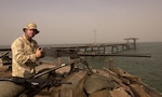 Petty Officer Second Class Paul F. Floge, a Coast Guard reservist with Coast Guard Port Security Unit 311 out of San Pedro, Ca., provides security with a .50 caliber machinegun on the Khawr al Amaya oil terminal off the coast of Iraq.
Flodge, who works full time for the Los Angeles Police Department, is one of many reservists called to active duty in support of Operation Iraqi Freedom.