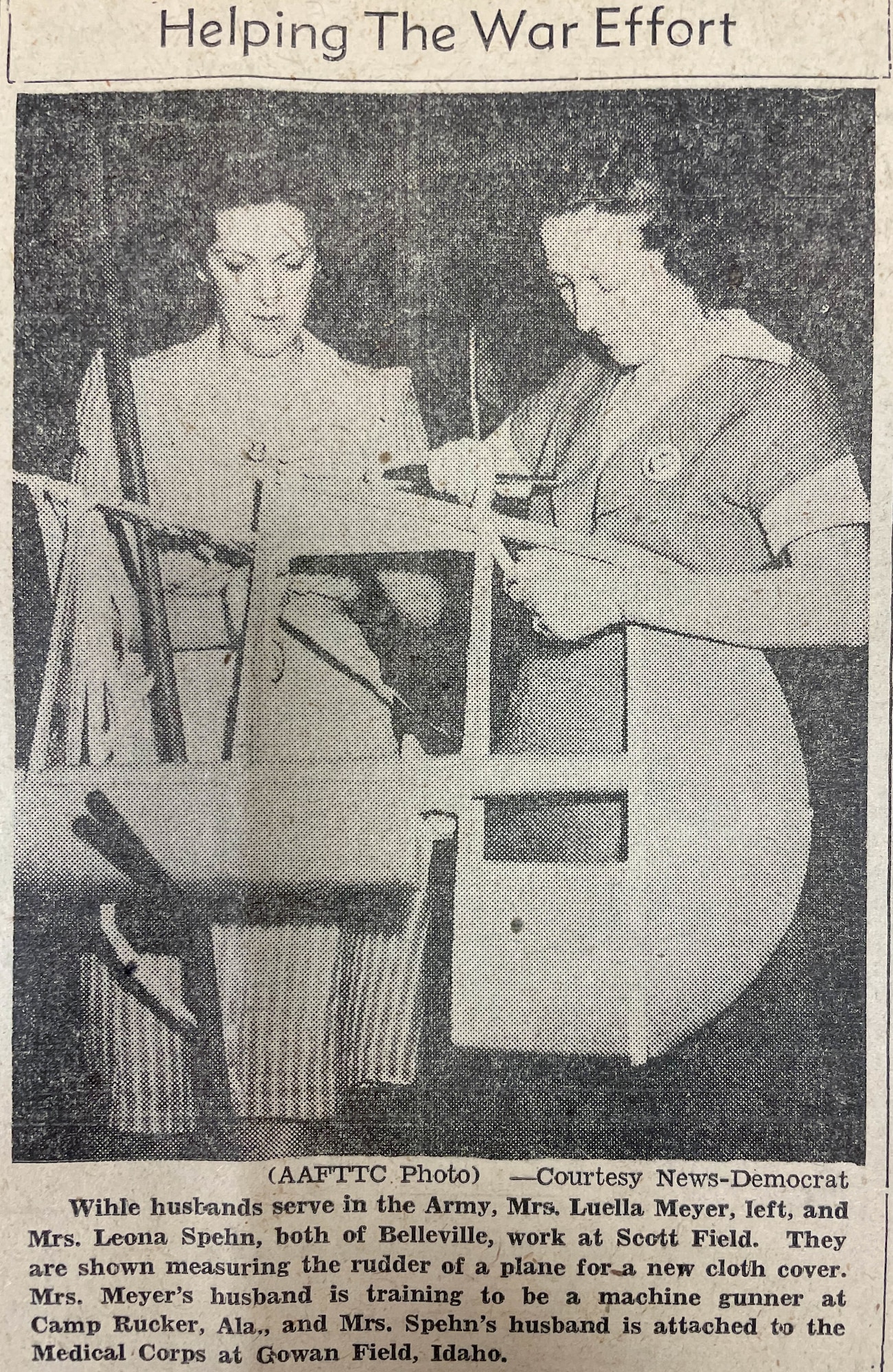 Women work on cloth in old newspaper clip.