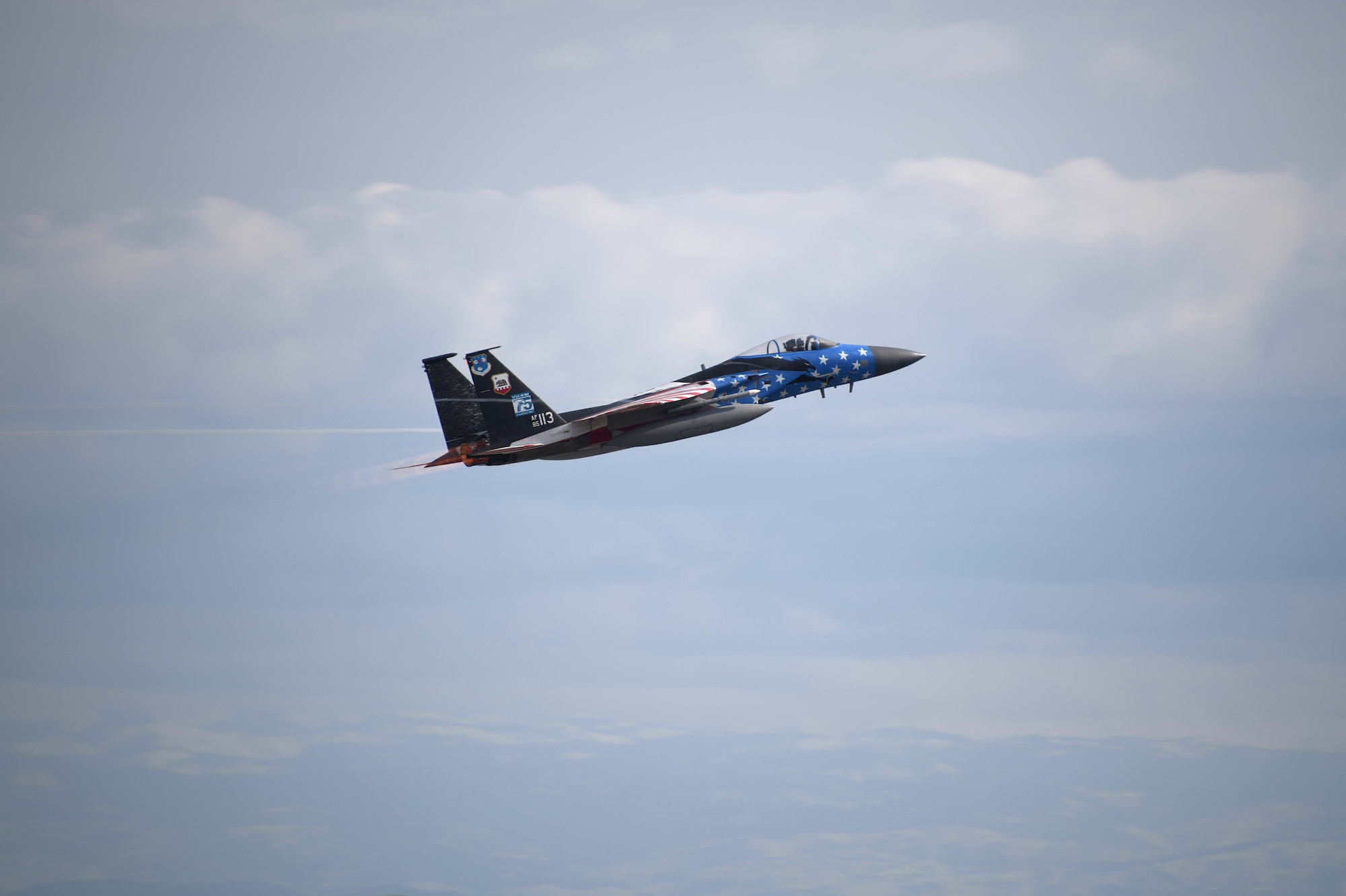 A photo of a military jet painted in a red, white and blue American flag pain scheme taken mid flight