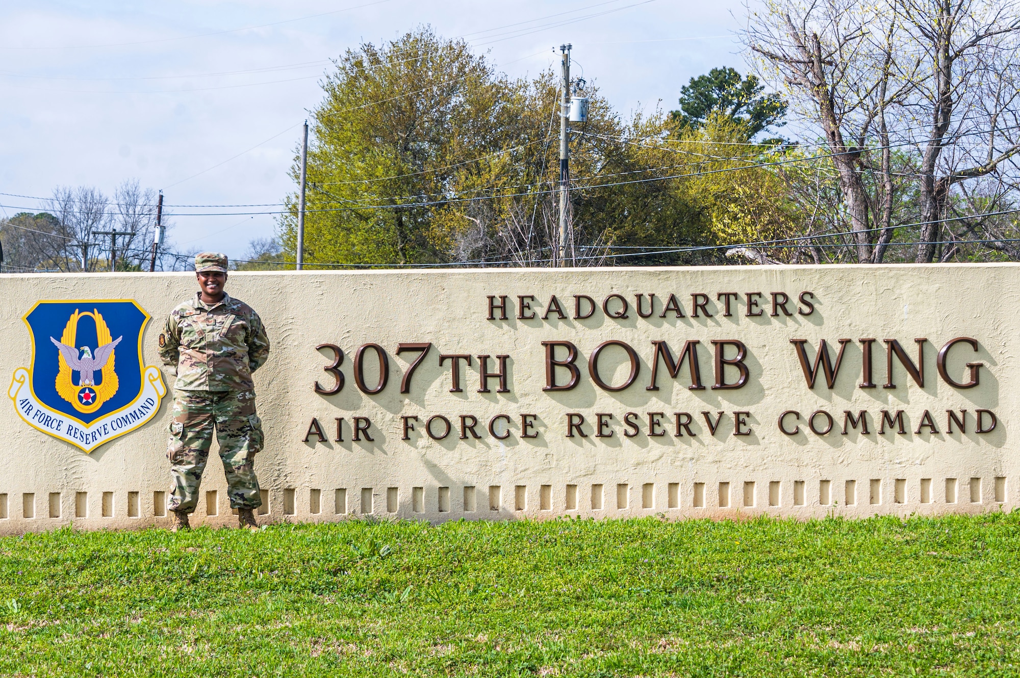 Airman poses in front of sign