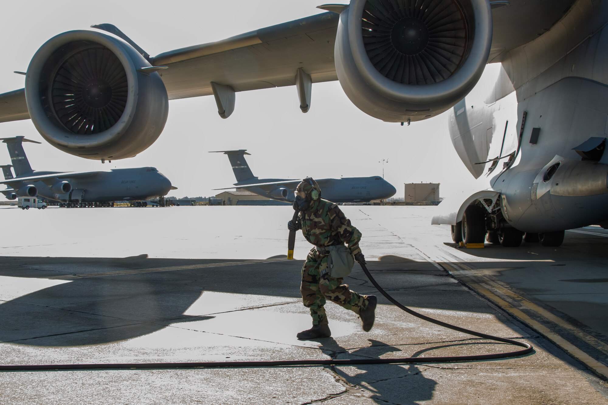 Airman walks away from aircraft holding  power cable.