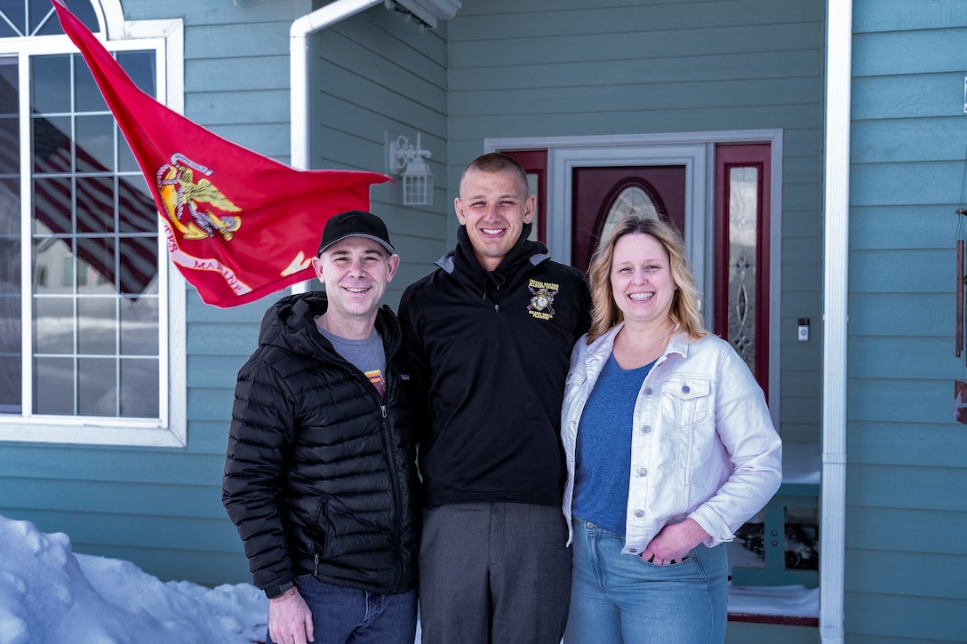 U.S. Marine Corps Cpl. Jackson Acree, a native of Palmer, Alaska, and member of the Marine Corps Silent Drill Platoon, poses with his parents in Anchorage, Alaska on March 2, 2023. The visit is part of a joint effort between Marine Barracks Washington and Marine Corps Recruiting Command designed to increase awareness of the Marine Corps, and prepare the unit for the upcoming summer parade season at Marine Barracks Washington D.C., the oldest post in the Marine Corps. (U.S. Marine Corps photo by Sgt. Menelik Collins)