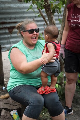 IMAGE: Taking a break: Janna Roland, the Naval Surface Warfare Center Dahlgren Division (NSWCDD) Test Execution Lead for the USS SECURE Team, holds 7-month-old Dillon during a home building project after Hurricane Ian ripped through his home in Port Charlotte, Florida Sept. 28, 2022. Roland, team leader for 516 Project Panama City, a Christian based 501c3 non-profit construction ministry, is recognized as a NSWCDD Distinguished Community Service Award recipient.