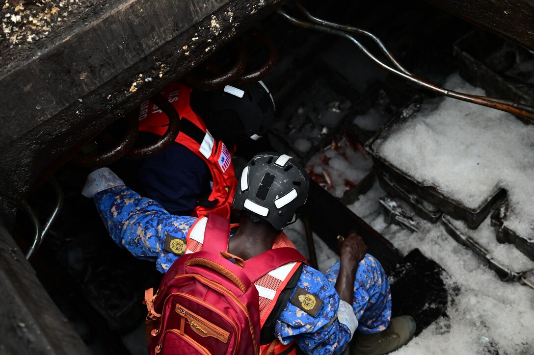 U.S. Coast Guard Ensign Mohammed Diakite, left, assigned to USCGC Spencer (WMEC 905), and The Gambia Navy Chief Petty Officer Jawundeh Jallow conduct a Gambian-led boarding of a fishing vessel in the Atlantic Ocean, Jan. 14, 2023. Spencer is on a scheduled deployment in the U.S. Naval Forces Africa area of responsibility, employed by the U.S. Sixth Fleet, to carry out joint training, exercises, and maritime security operations alongside African partners in support of U.S. interests abroad to foster regional partnerships, promote regional stability, and strengthen international maritime governance. (U.S. Coast Guard photo by Petty Officer 3rd Class Mikaela McGee)