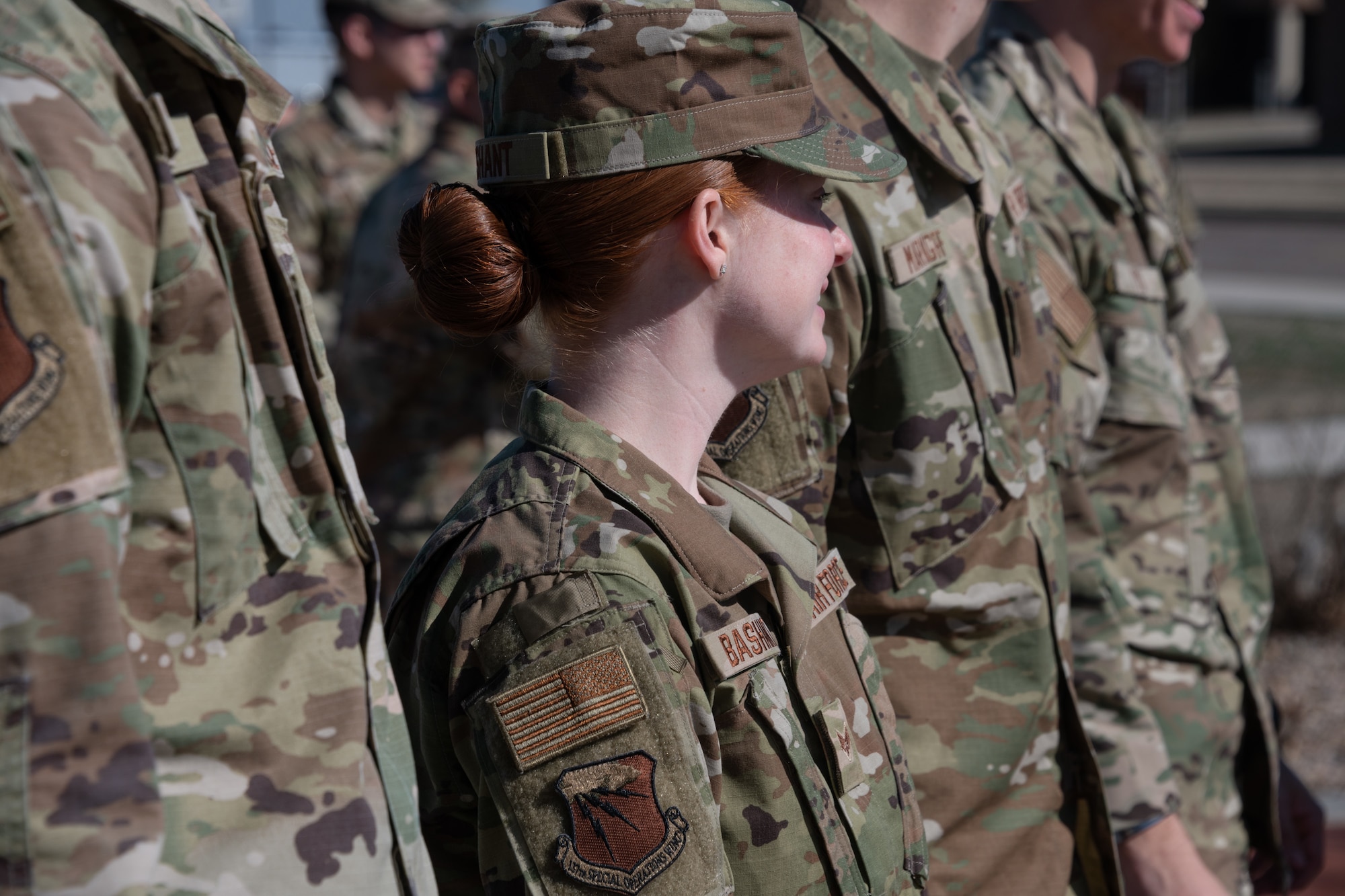 An airman recently returned from training wears their newly-issued wing patch during a ceremony