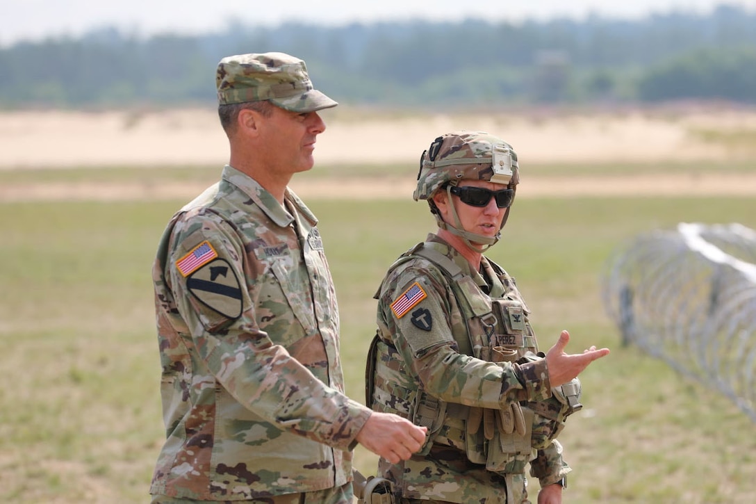Army Col. Carrie Perez, commander of the 36th Sustainment Brigade, 36th Infantry Division, Texas Army National Guard provides a brief to Brig. Gen. Bryan Howay, Deputy Commanding General, First Army Division East during his visit to the Northern Strike exercise at Camp Grayling Joint Maneuver Training Center, Aug. 1, 2021.