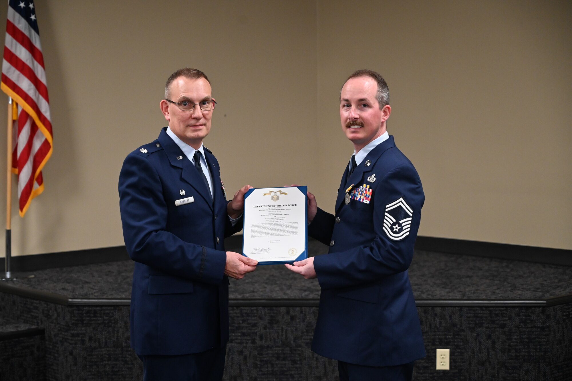 Chief Green stands holding an award with Lt Colonel Garrett