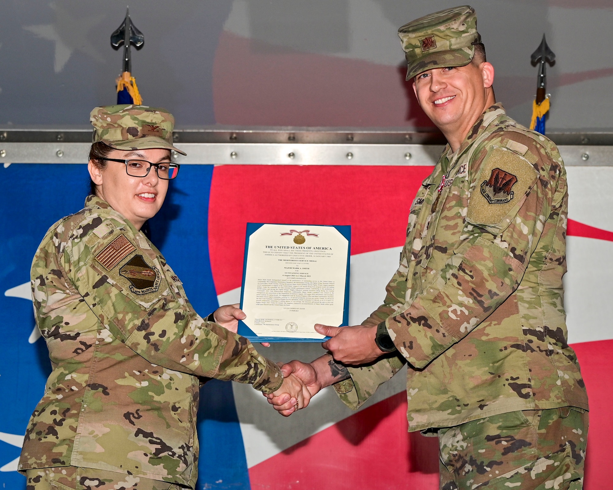 Col. Kathryn Roman, left, 4th Maintenance Group commander, hands an award to Maj. Mark Smith, 4th Component Maintenance Squadron outgoing commander, during a change of command ceremony at Seymour Johnson Air Force Base, North Carolina, March 3, 2023. The 4th CMS is the third largest squadron in the 4th Fighter Wing with over 450 active duty and civilian members. (U.S. Air Force photo by Staff Sgt. Sean Martin)