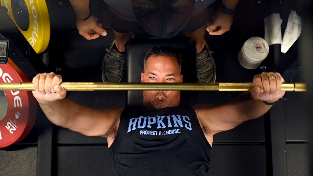 Hopkins is seen from above, grimacing as he benchpresses.