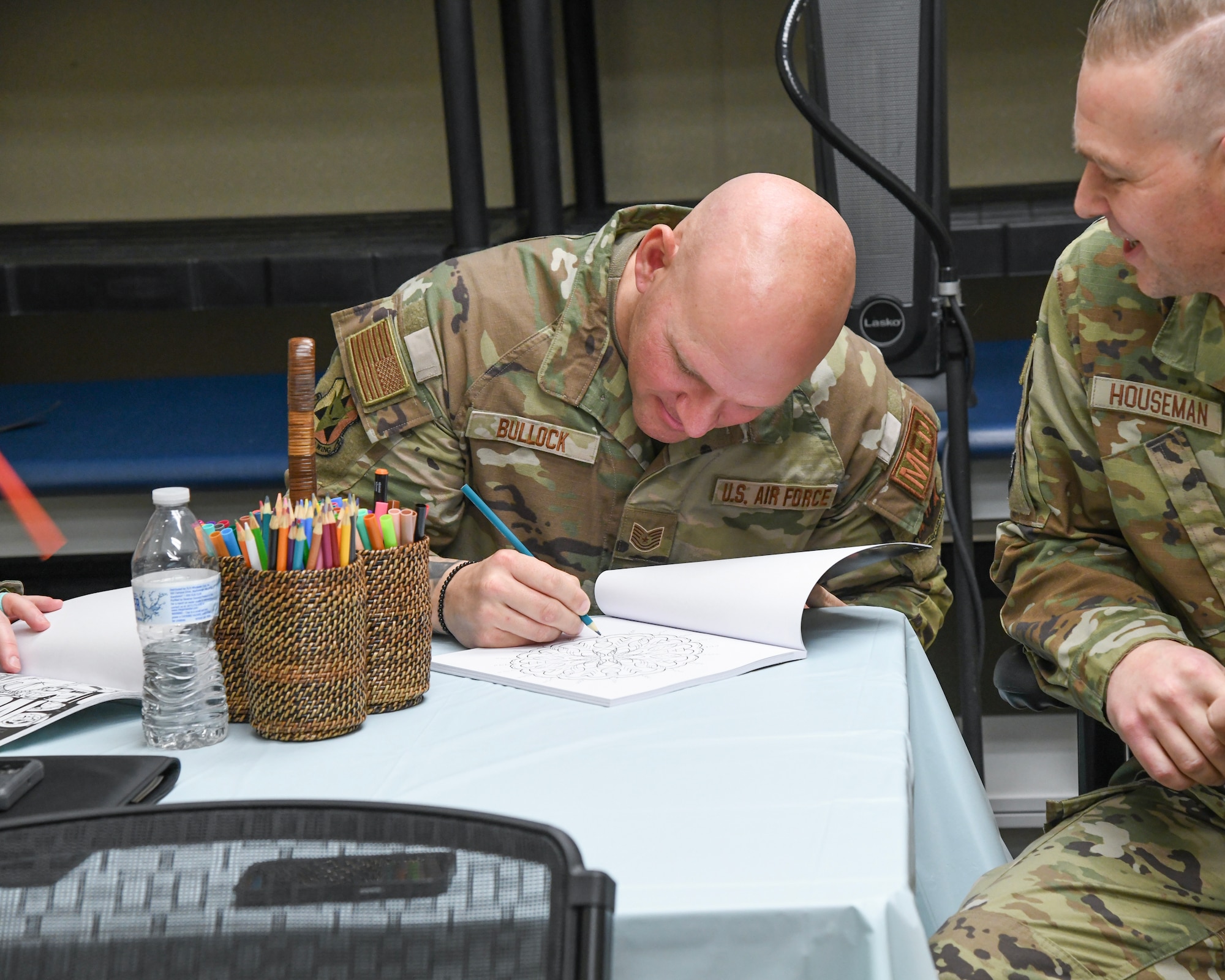A photo of Tech. Sgt. Ryan Bullock, a technician with the 177th Medical Group Mental Health and Wellness Center (MHAWC) colors in a coloring book.