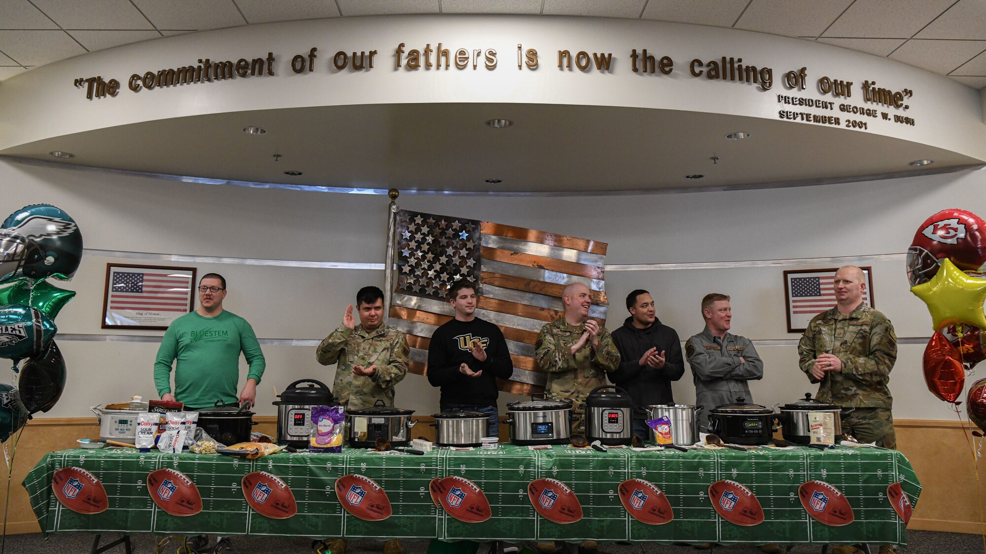 Seven individuals applaud at a chili cook-off event