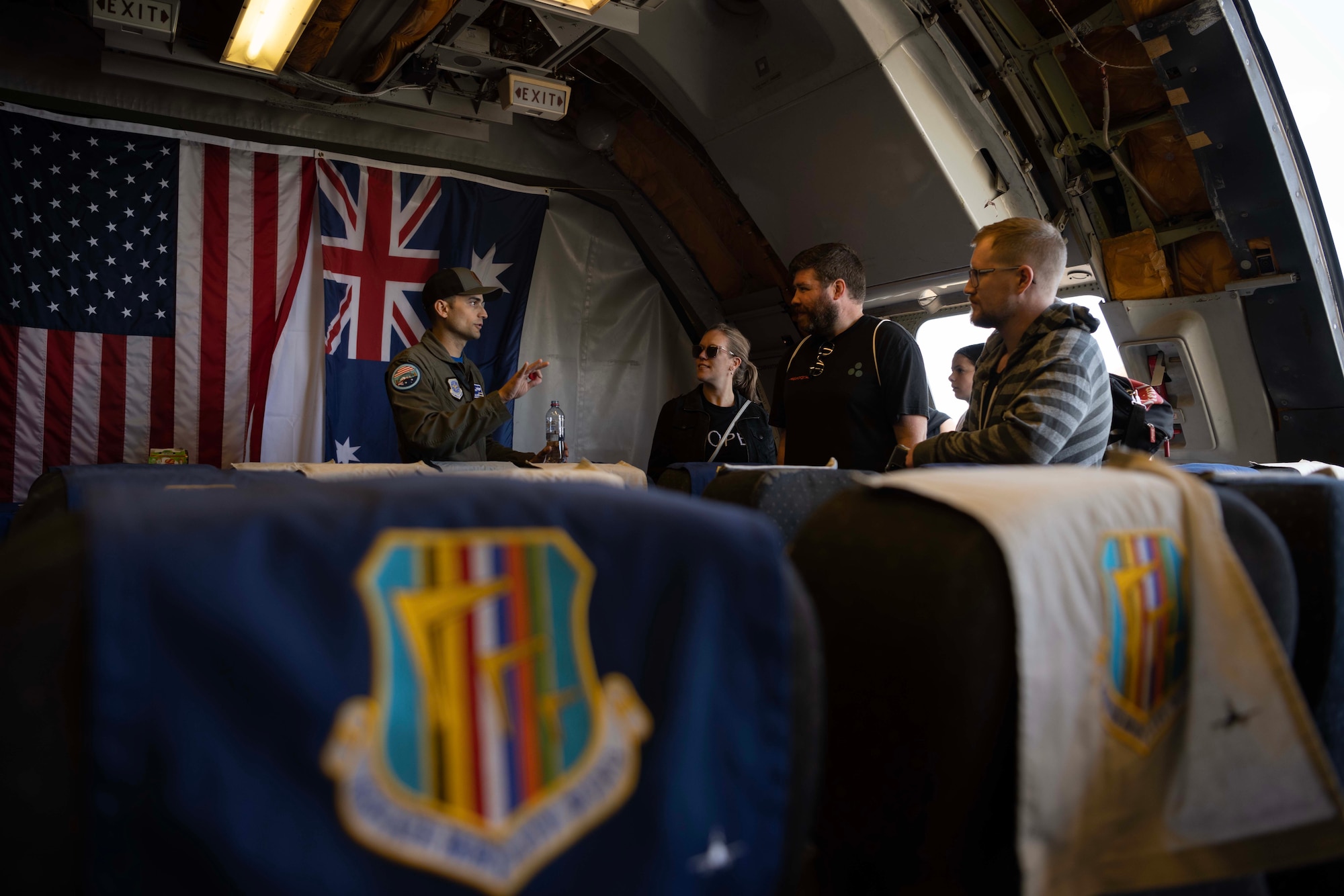 An Airman interacts with visitors inside an aircraft.