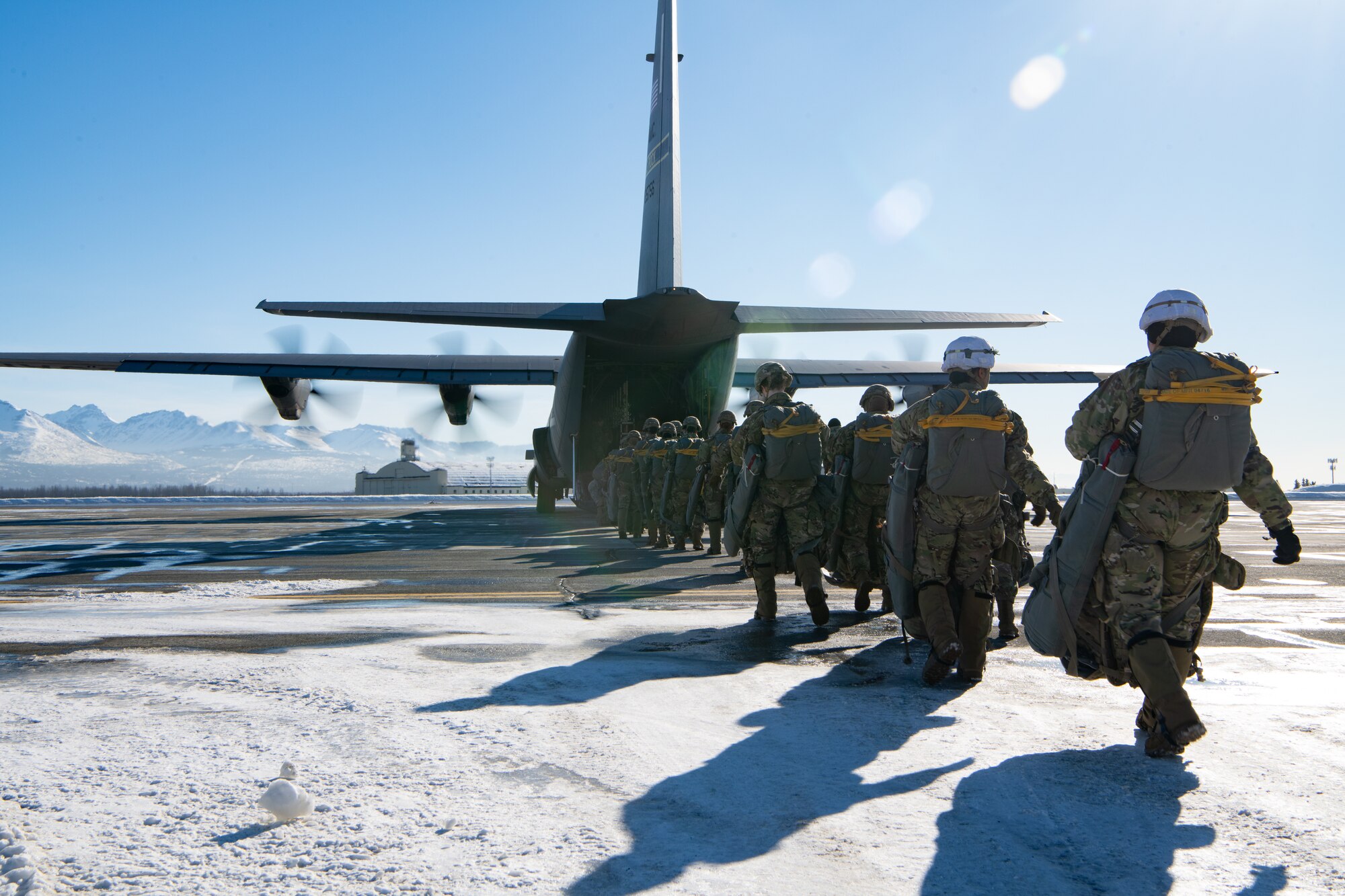 A photo of paratroopers stepping towards an awaiting aircraft