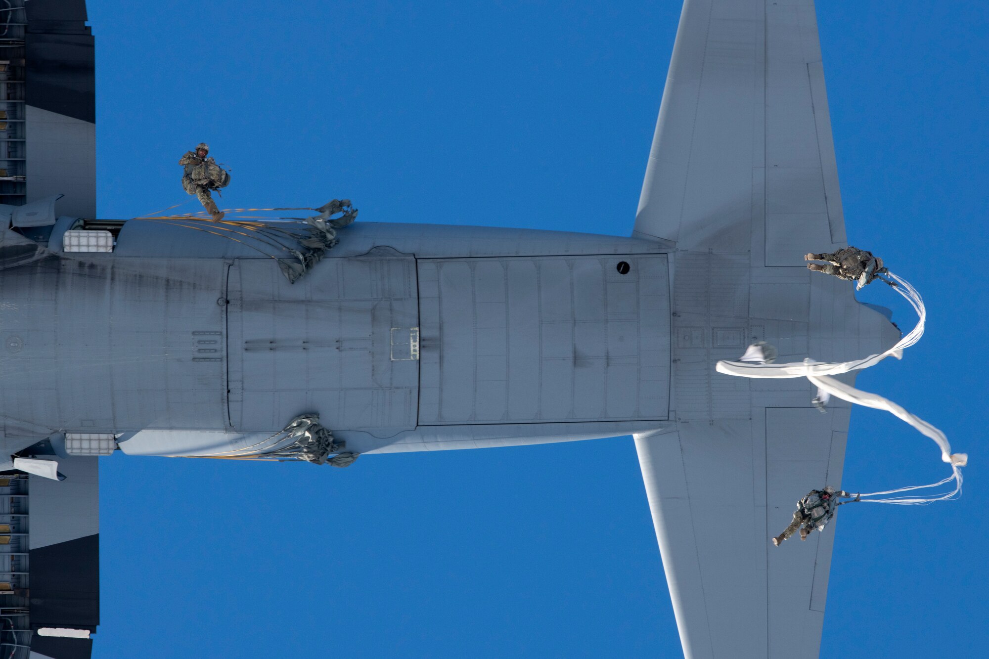 A photo of paratroopers leaping from an aircraft