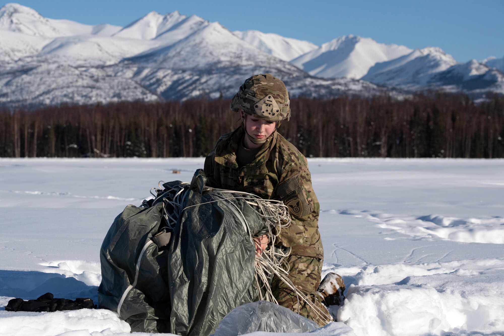 A photo of a paratrooper recovering her parachute